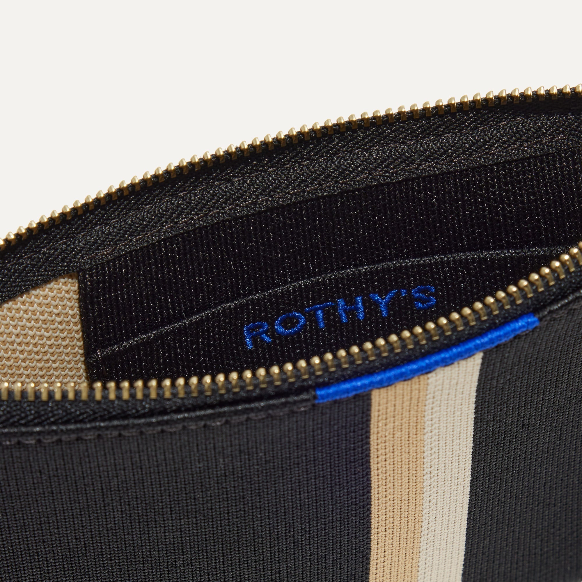 A closeup of The Wallet Wristlet in Black Portobello Stripe, focusing on the inner card slip.