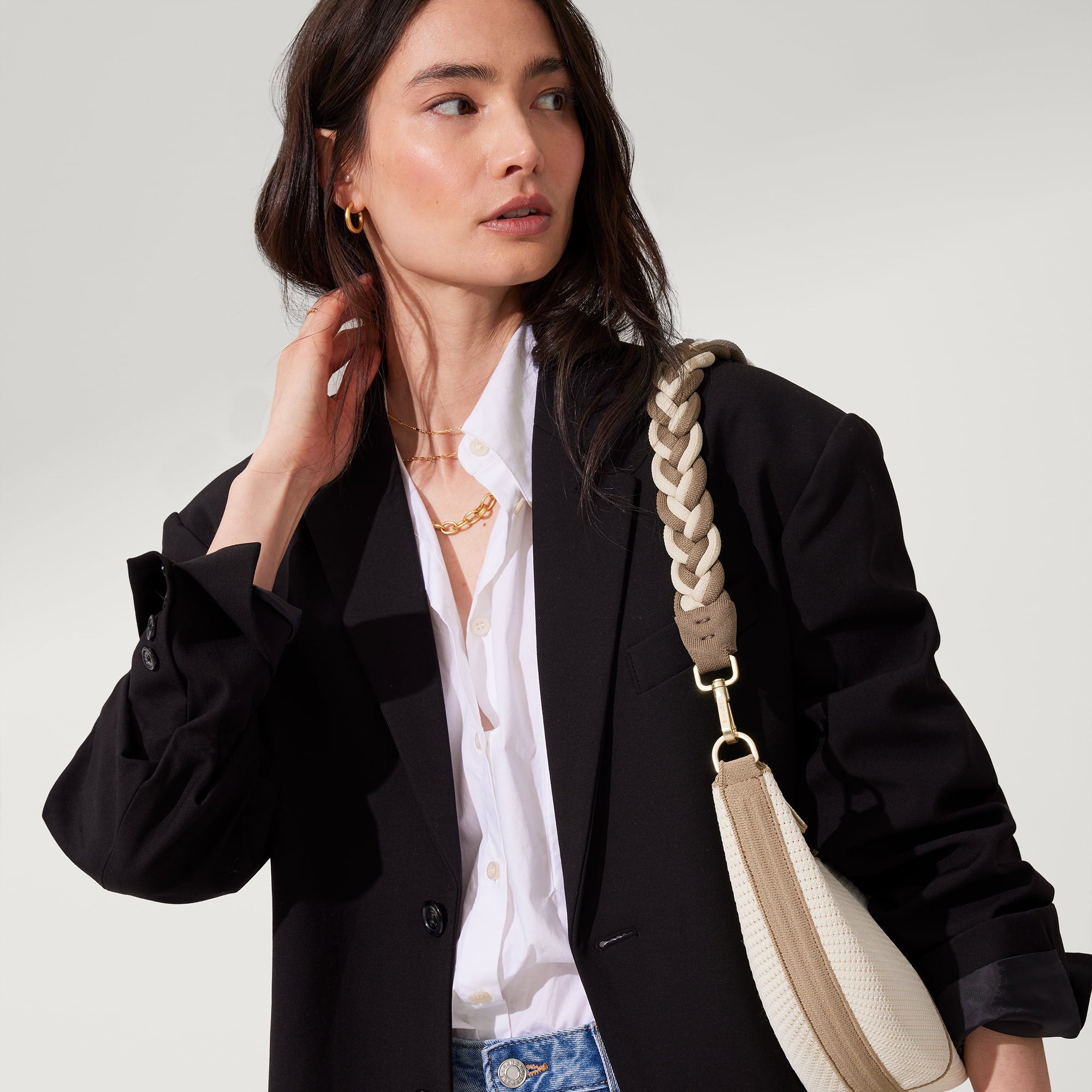 hover | The Braided Shoulder Strap in Cream & Cocoa, shown paired with The Crescent Bag, worn by a model and shown from the side. 