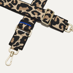 A closeup of The Crossbody Strap in Desert Cat, focusing on the end snap hooks and sliding buckle.