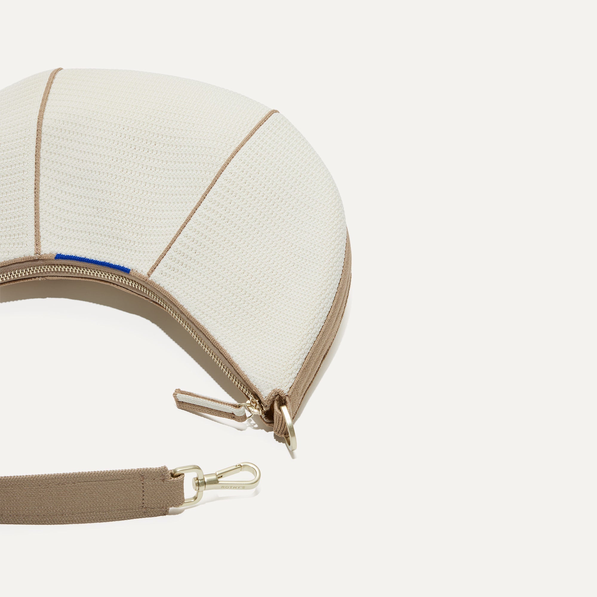 A close up of The Crescent Bag in Celestine, with the shoulder strap detached. 