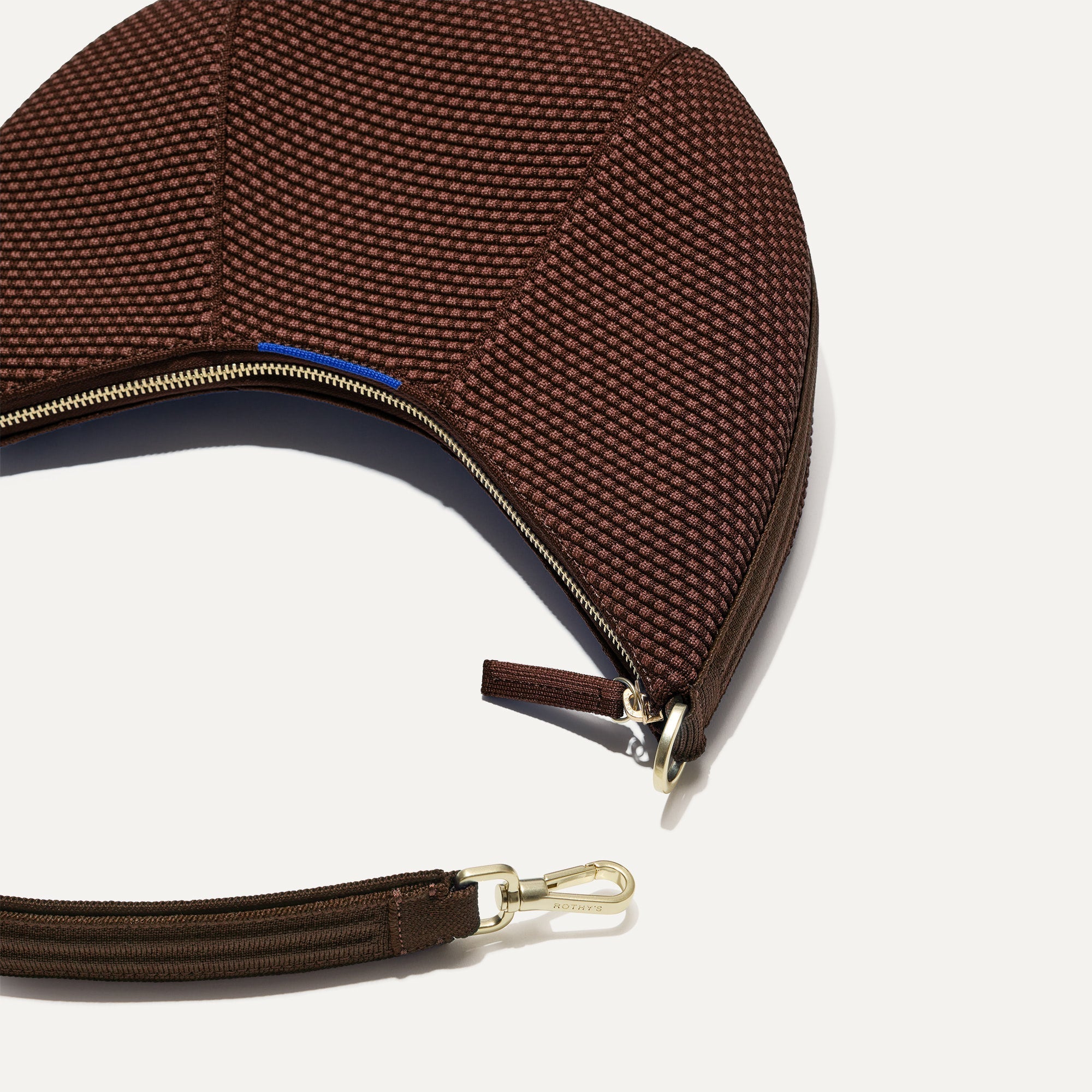 A close up of The Crescent Bag in Eclipse, with the shoulder strap detached.