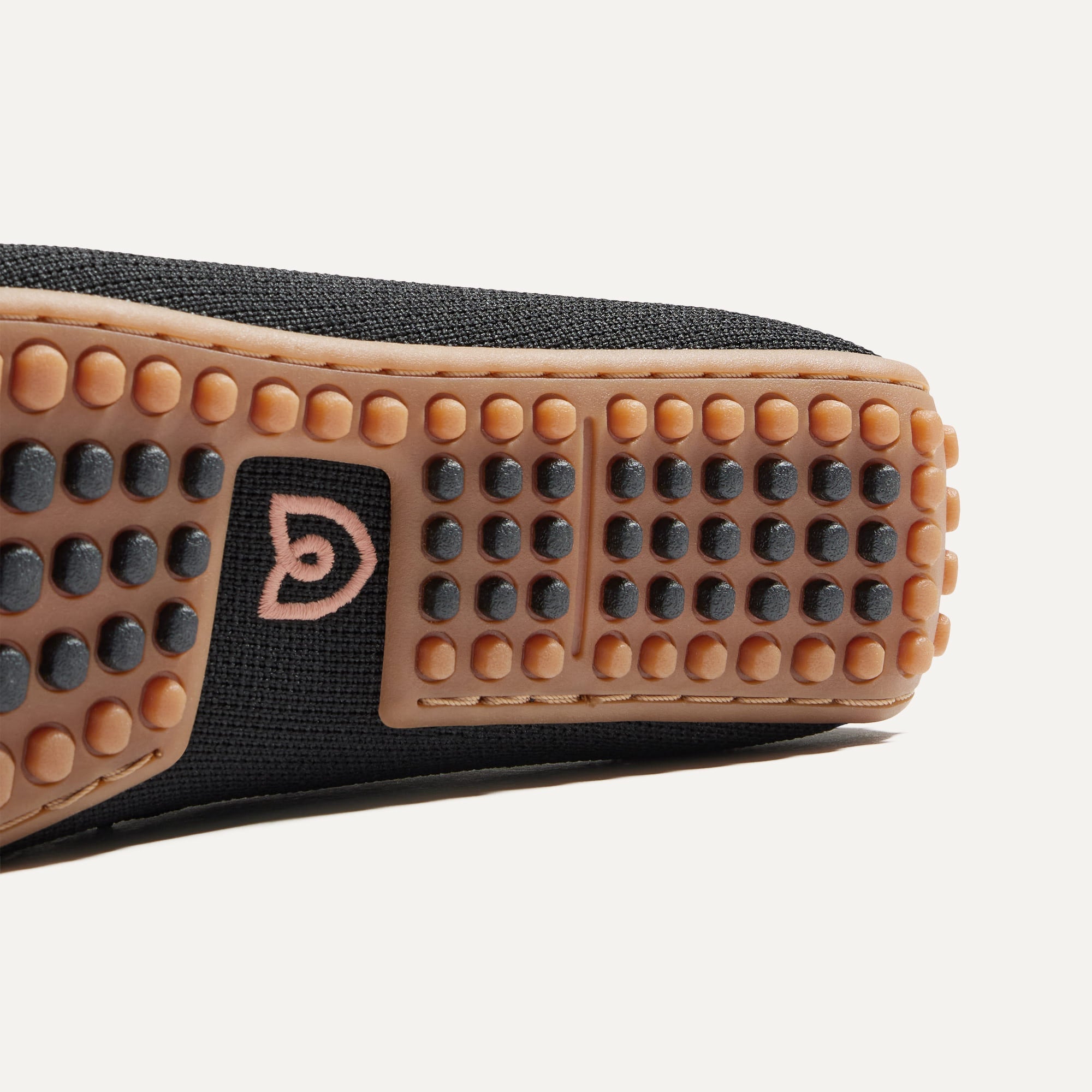 Close up of the heel of The Braid Driver in Black, with Rothy's signature blue halo. 