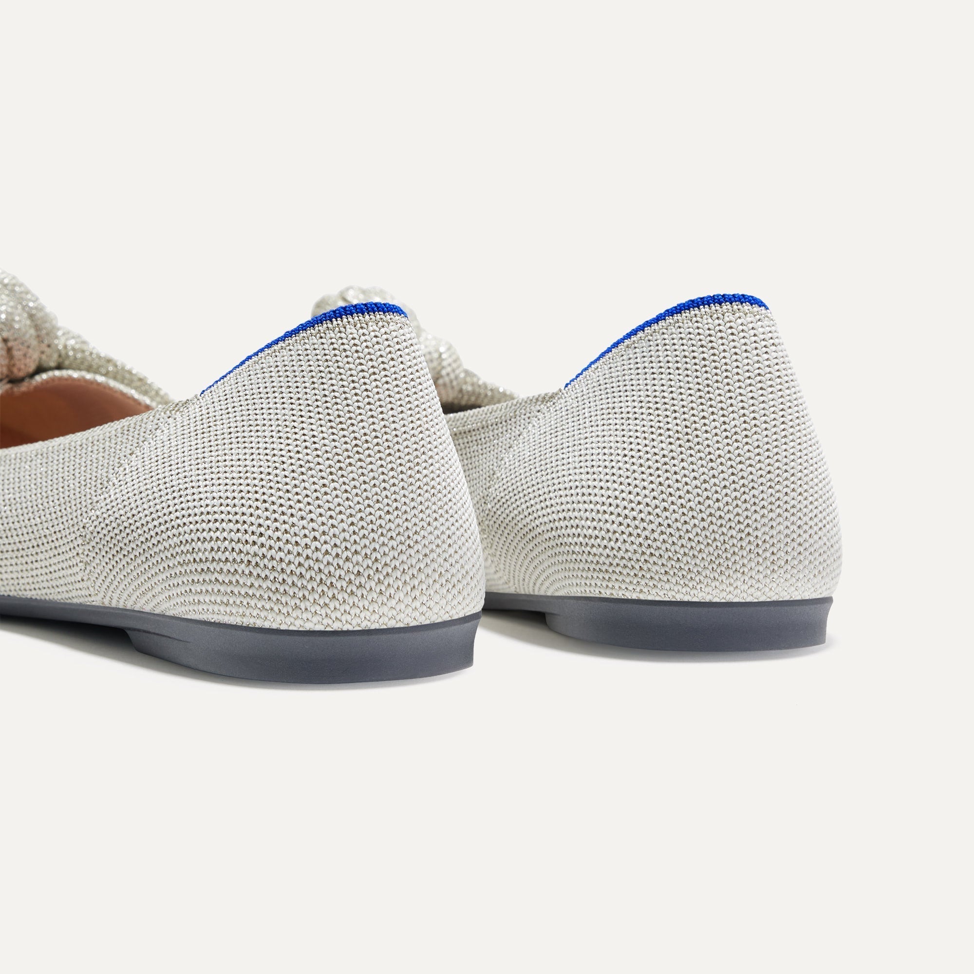 Close up of the heel of The Knot Point II in Diamond Metallic, with Rothy's signature blue halo. 