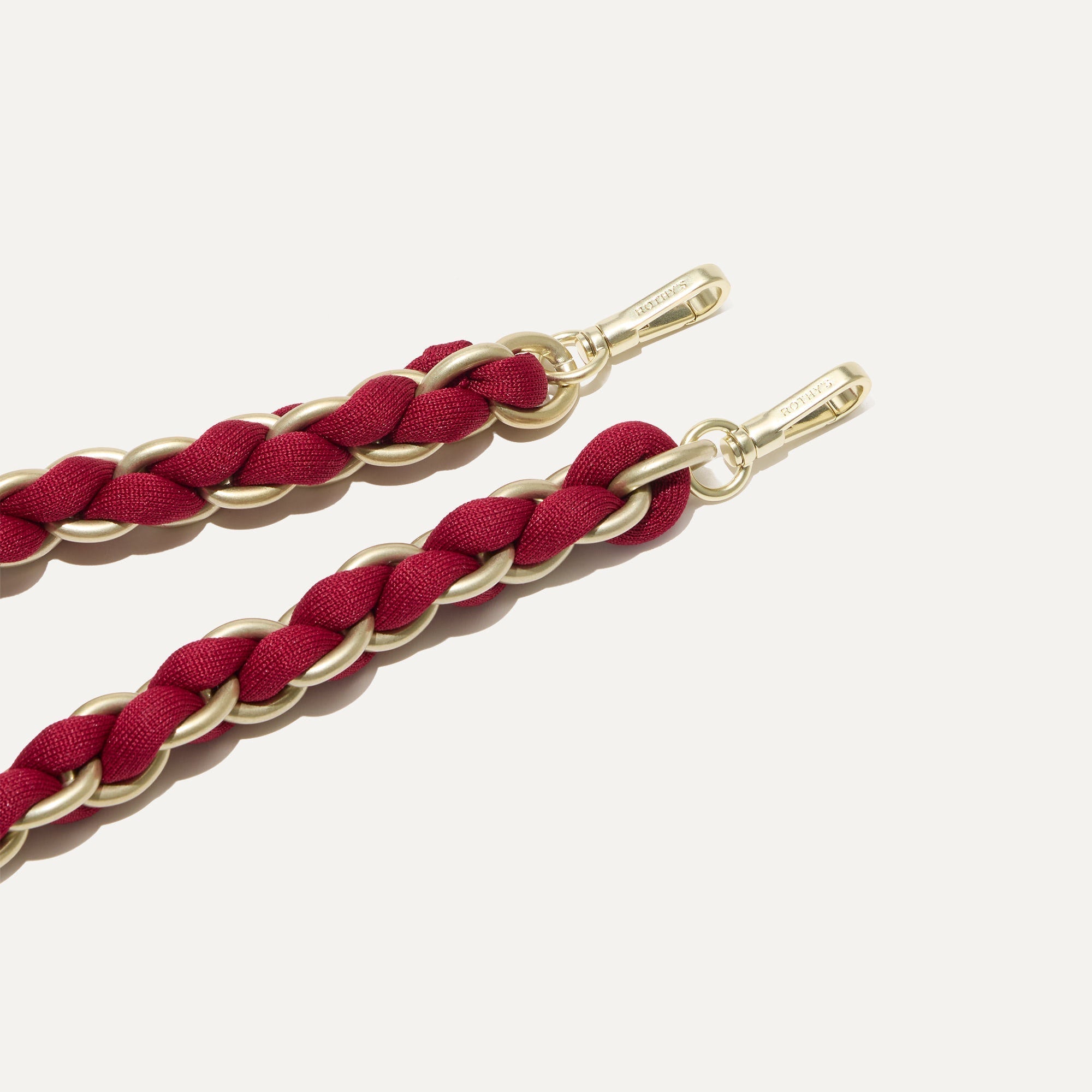 A close-up of The Shoulder Strap in Cranberry Chain, focusing on the end snap hooks. 