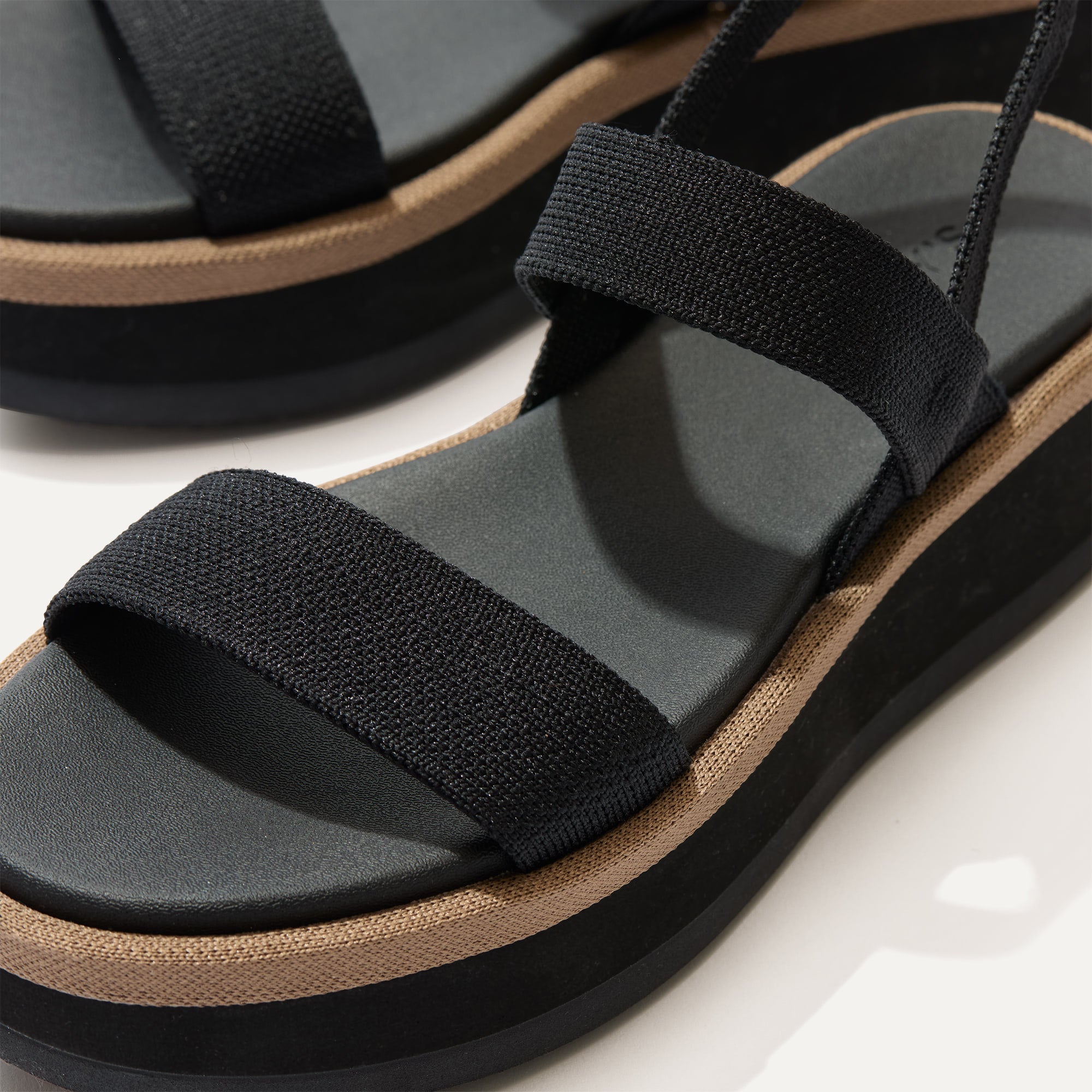 Close up of the knit rand of The Lightweight Wedge Sandal in Pepper, shown in diagonal view. 