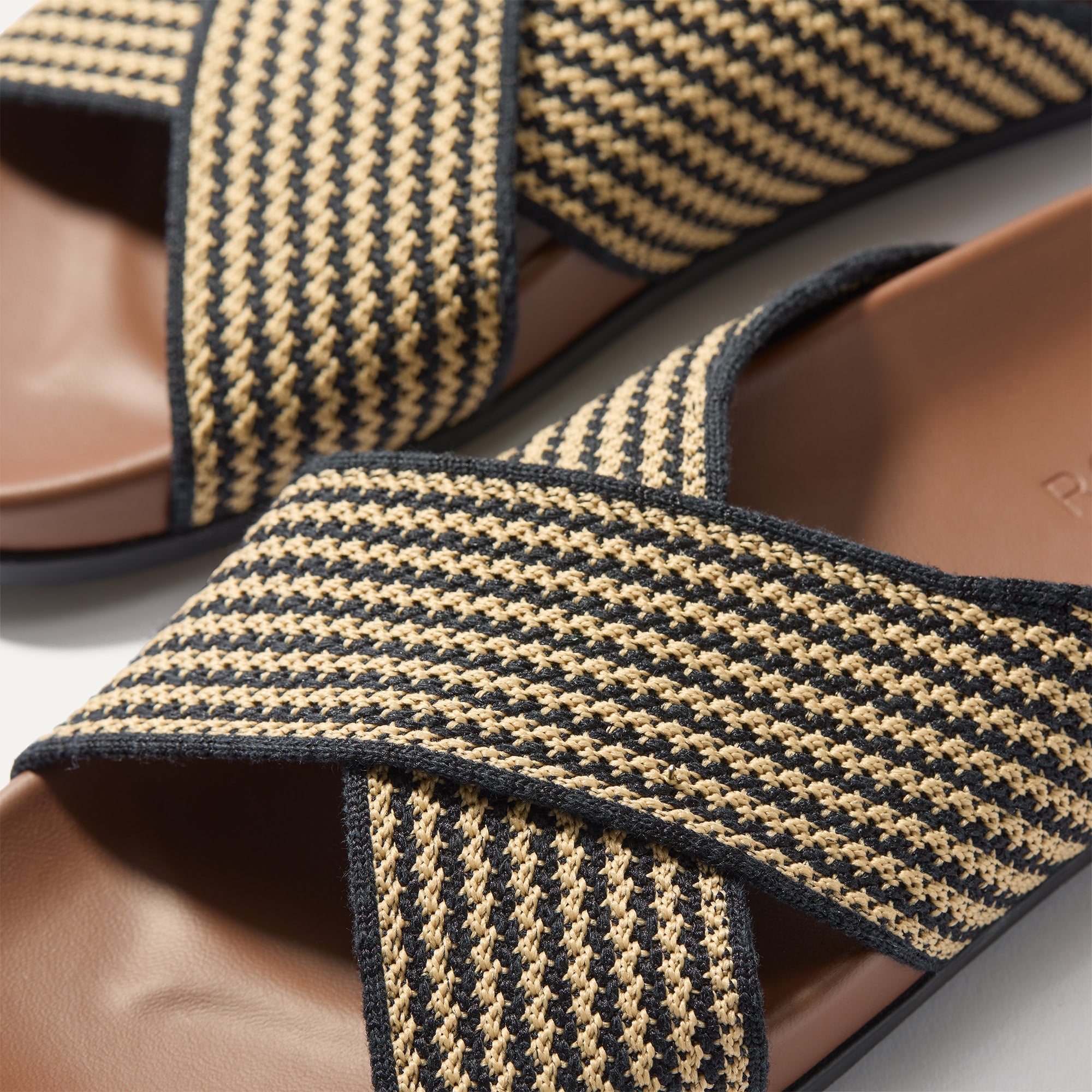 Close up of the crossing knit straps and toe of The Weekend Slide in Toffee Stripe, shown in diagonal view. 