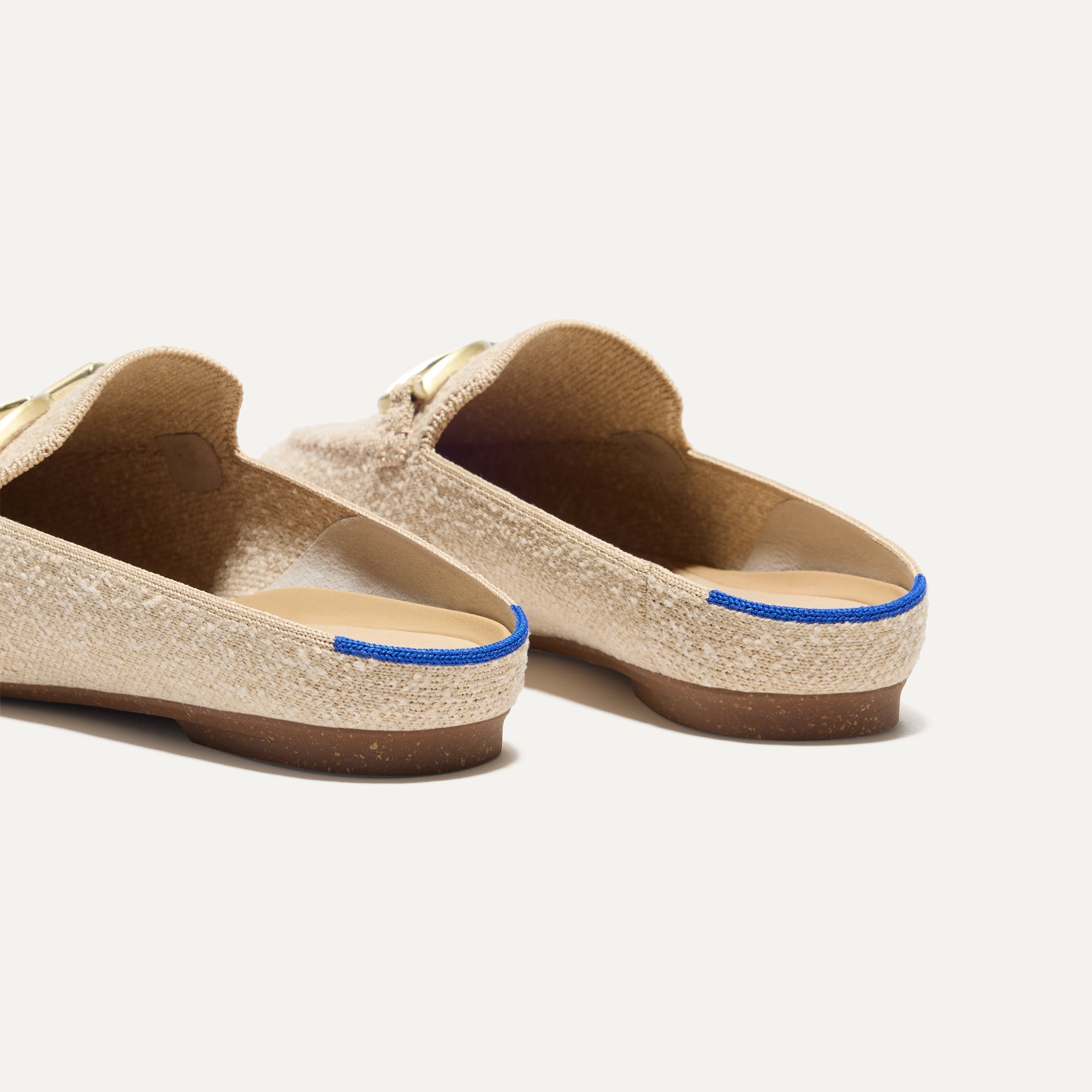 Close up of the heel of The Double Bit Loafer Mule in Bunny Bouclé, with Rothy's signature blue halo. 