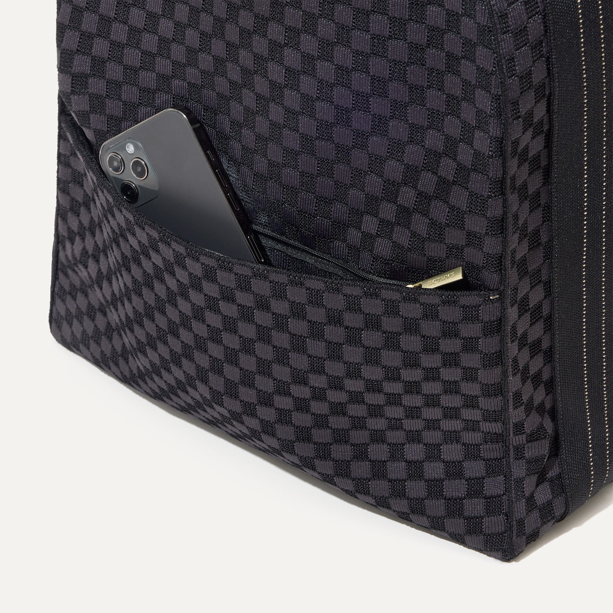 The front pocket of The Backpack in Black Sand.