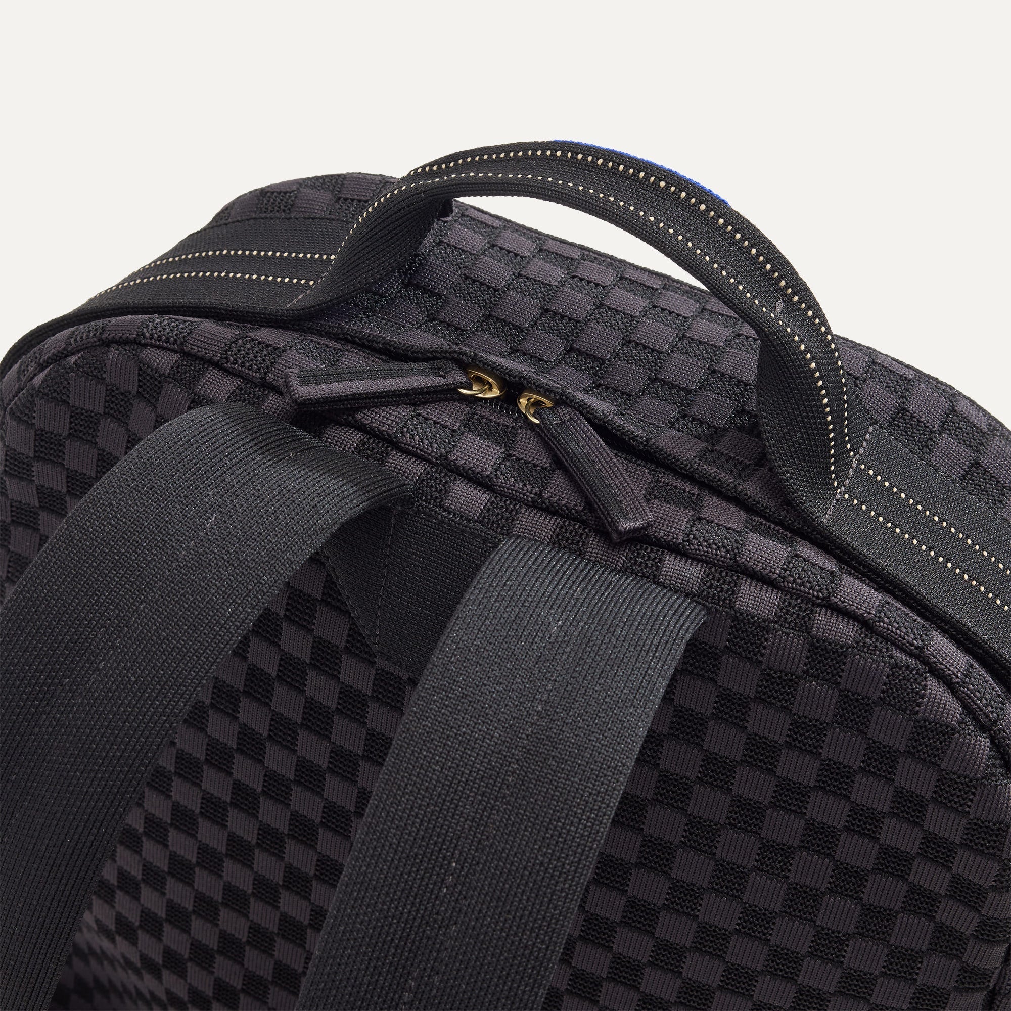 A close up of The Backpack in Black Sand showing the hidden zipper closure.