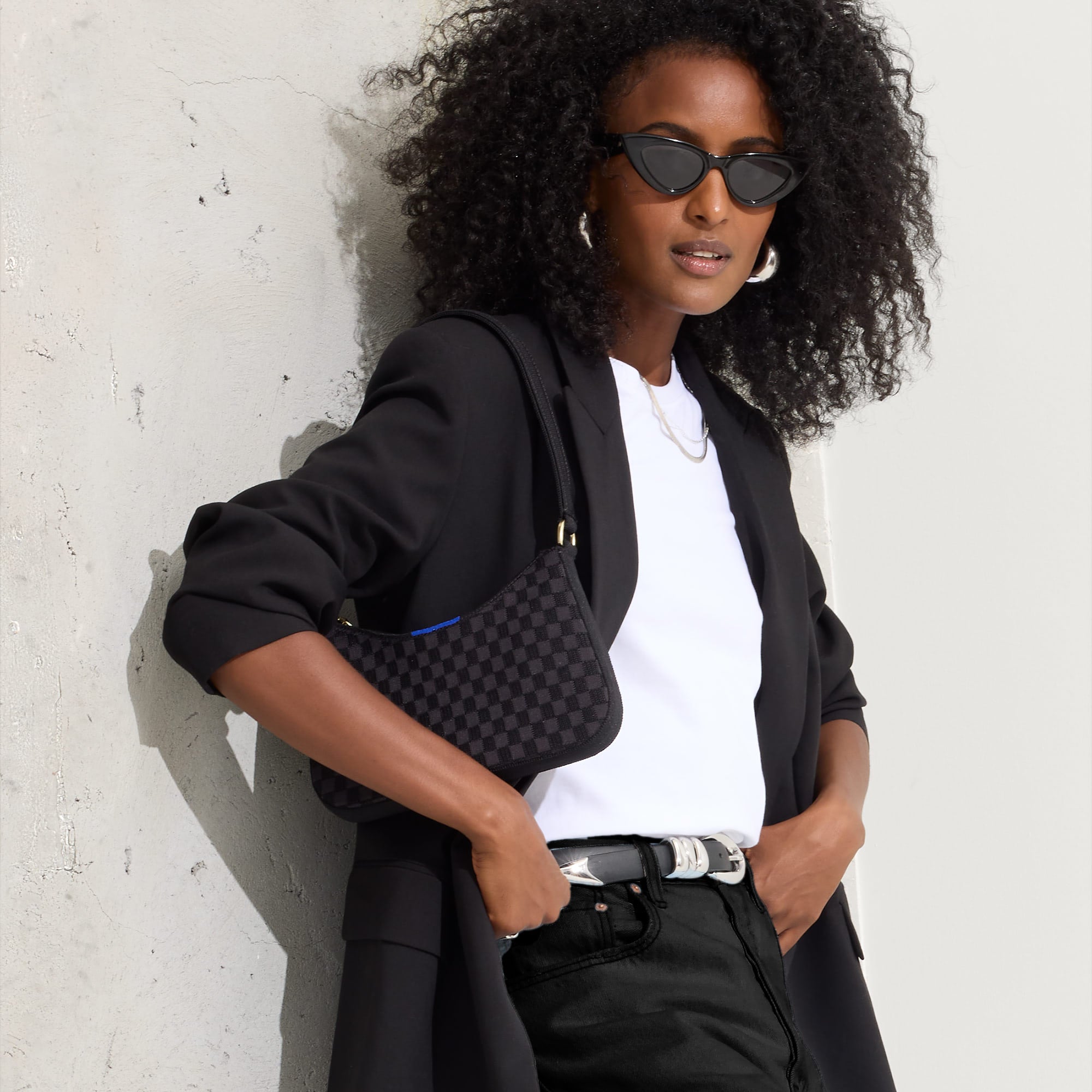 hover | Model holding The Mini Shoulder Bag in Black Sand.