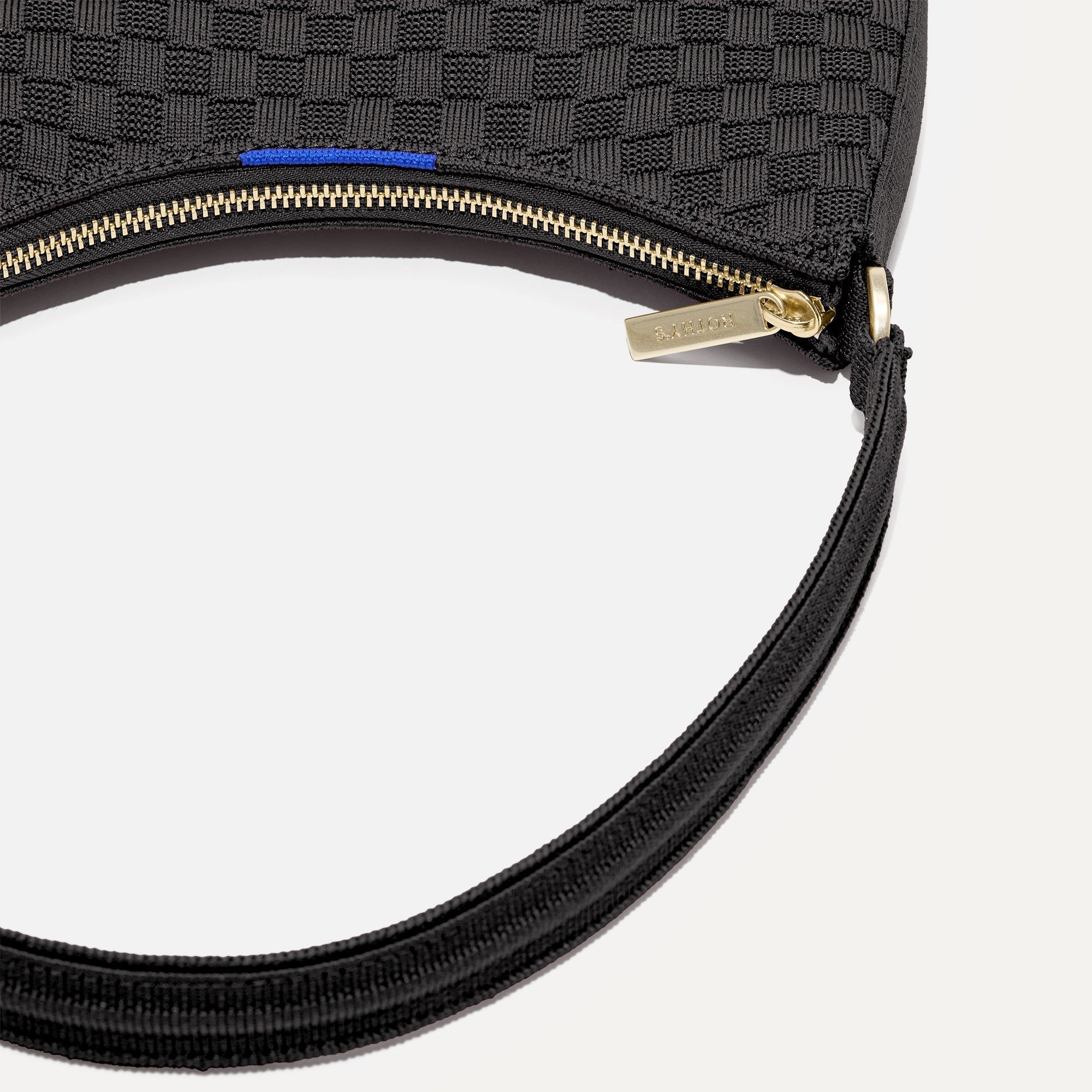 A close up of The Mini Shoulder Bag in Black Sand focusing on the zip closure and handles.