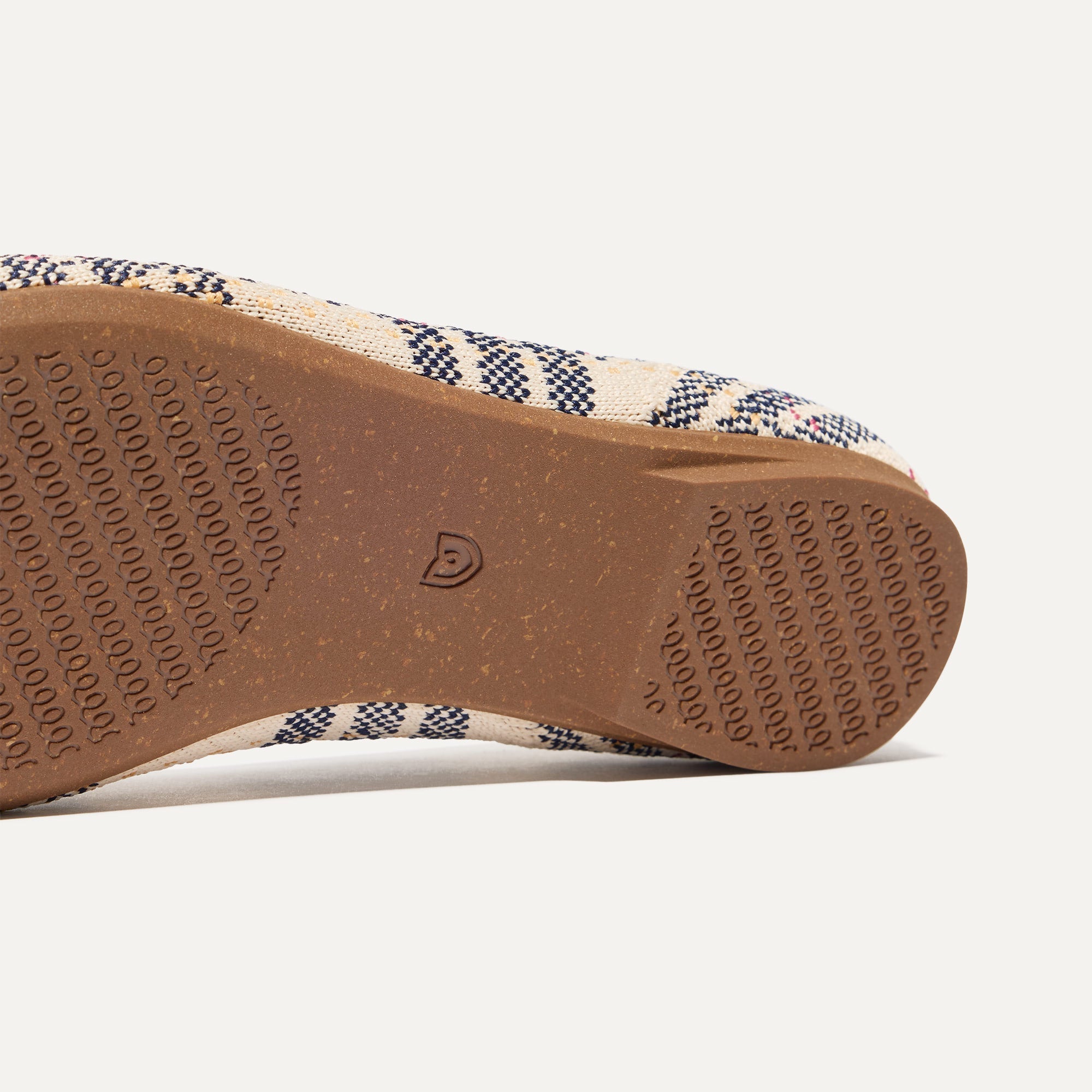 The sole of The Almond Tassel Loafer in Spring Plaid shown in diagonal view.