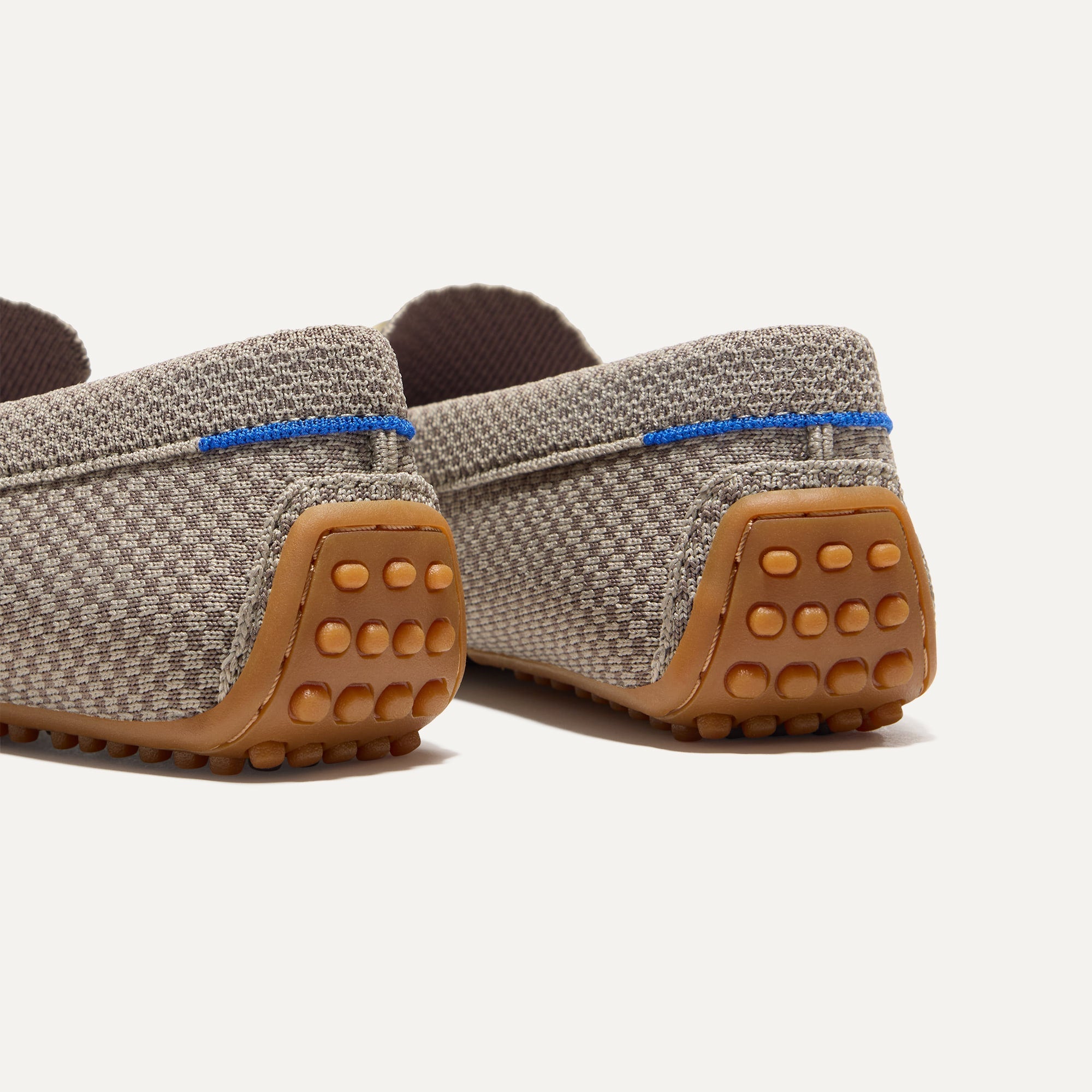 Close up of the heel of The Double Bit Driver in Latte Micro Check, with raised nub outsoles and Rothy's signature blue halo. 