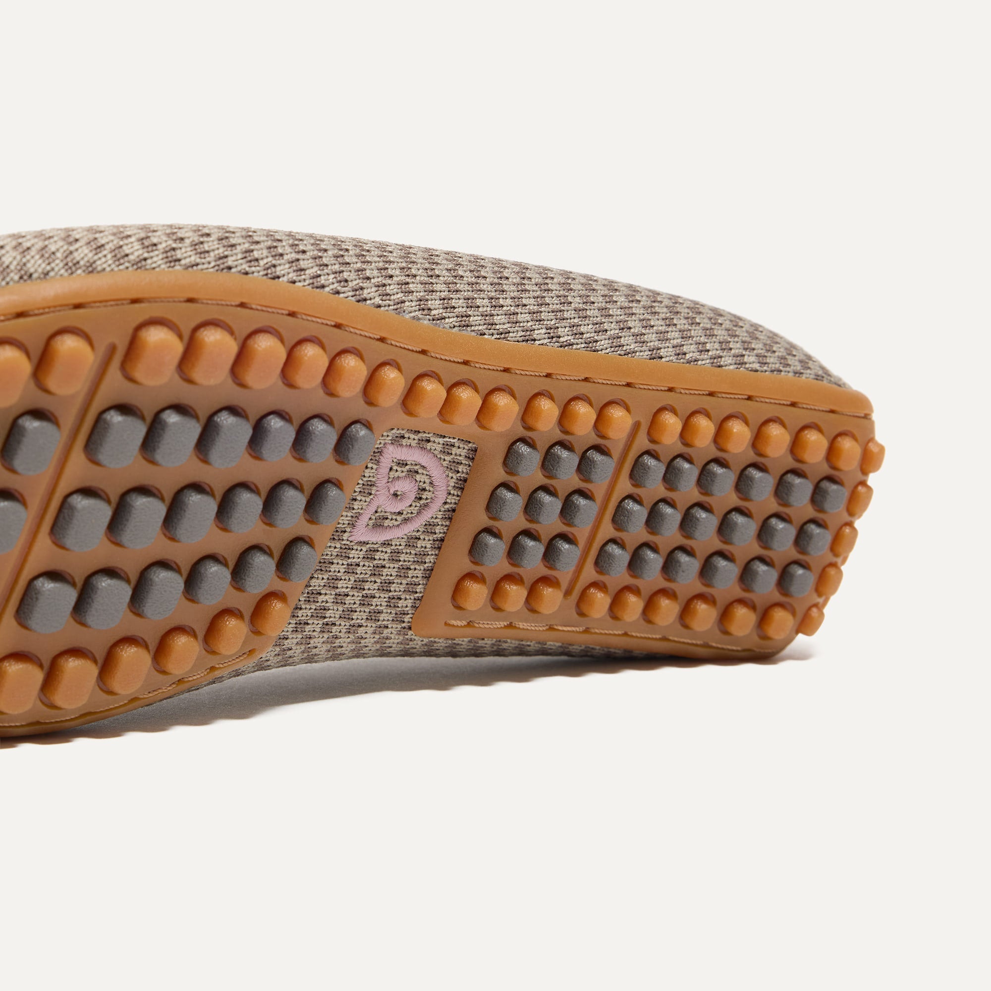 Close up of the raised nub outsoles of The Double Bit Driver in Latte Micro Check.