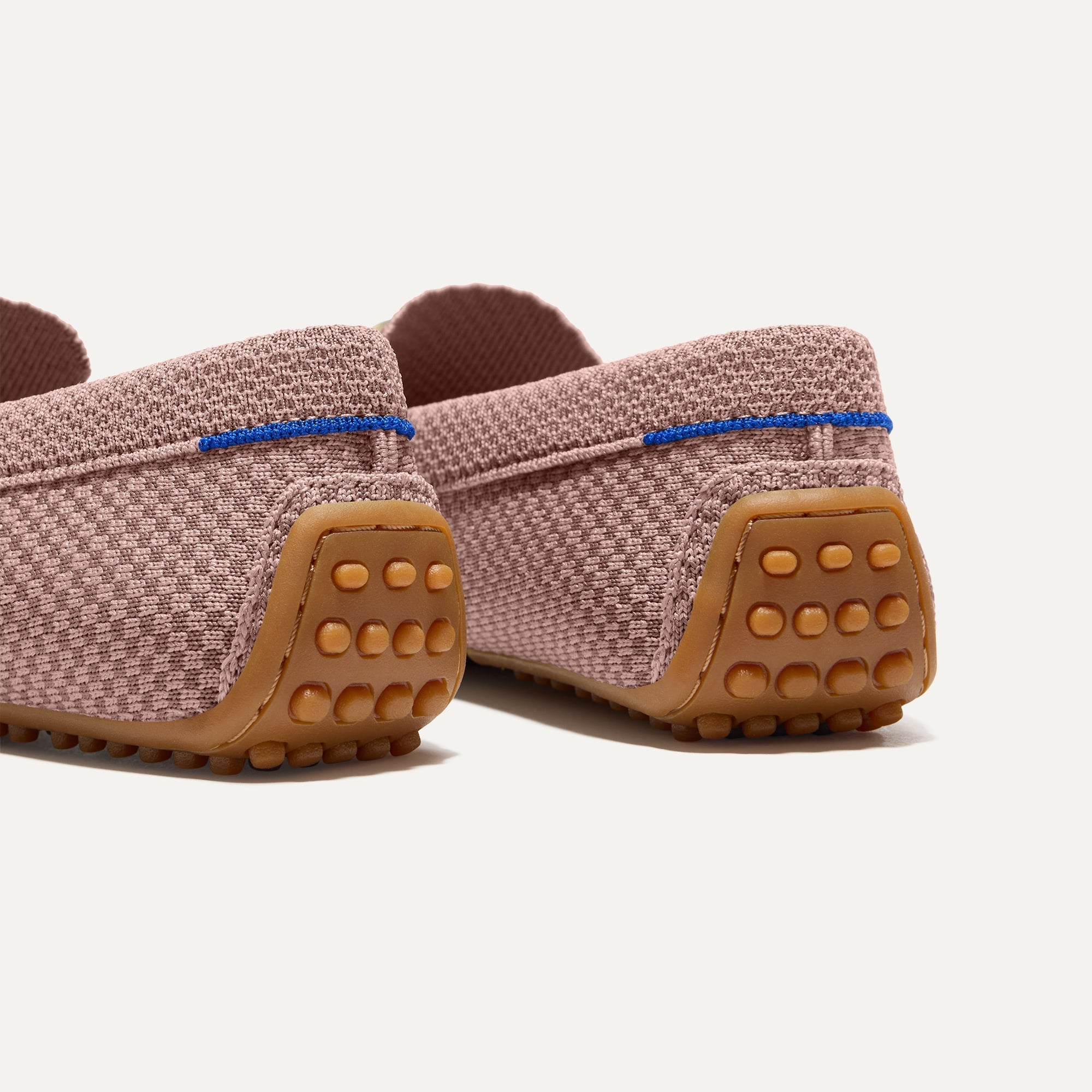 Close up of the heel of The Double Bit Driver in Rose Micro Check, with raised nub outsoles and Rothy's signature blue halo. 