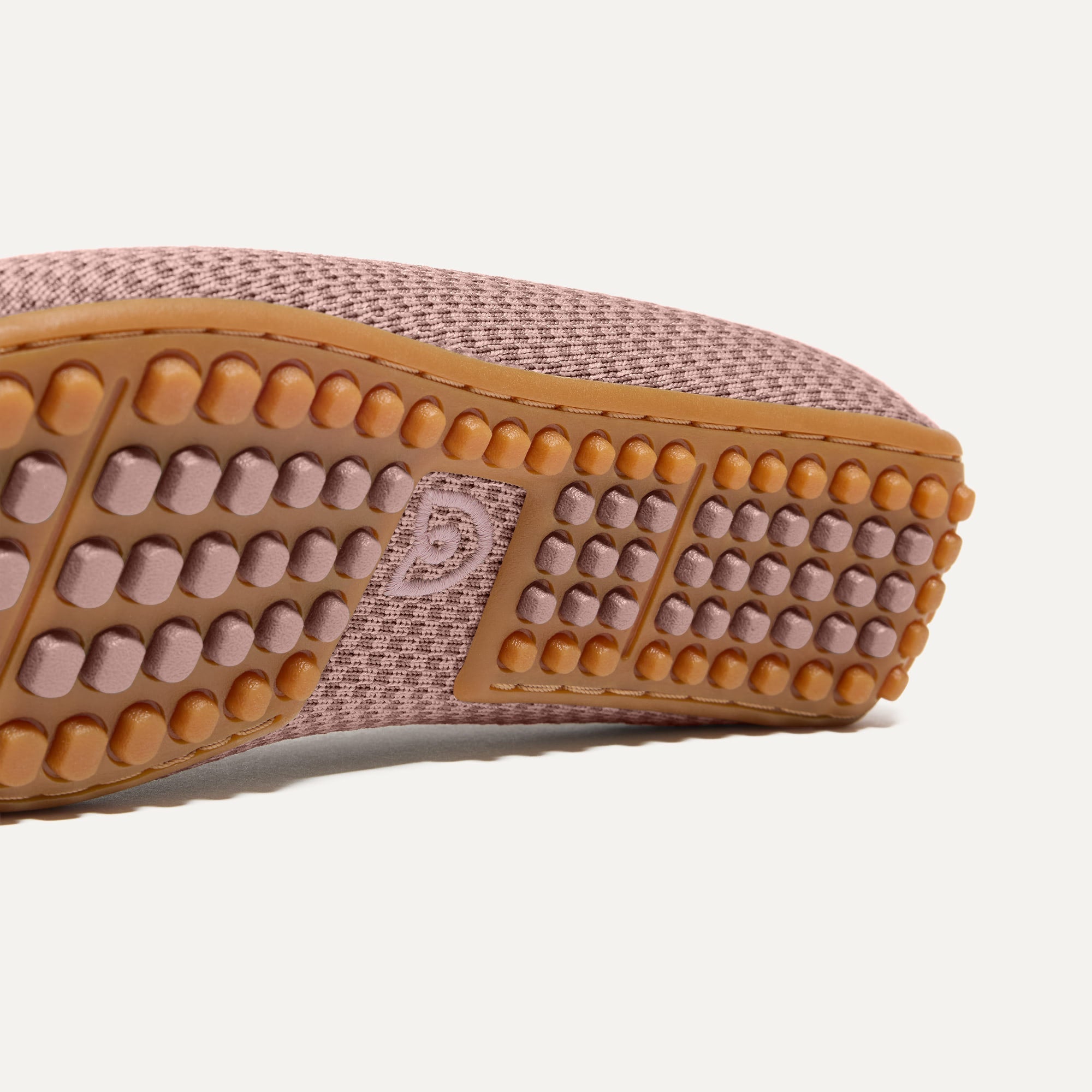 Close up of the raised nub outsoles of The Double Bit Driver in Rose Micro Check.