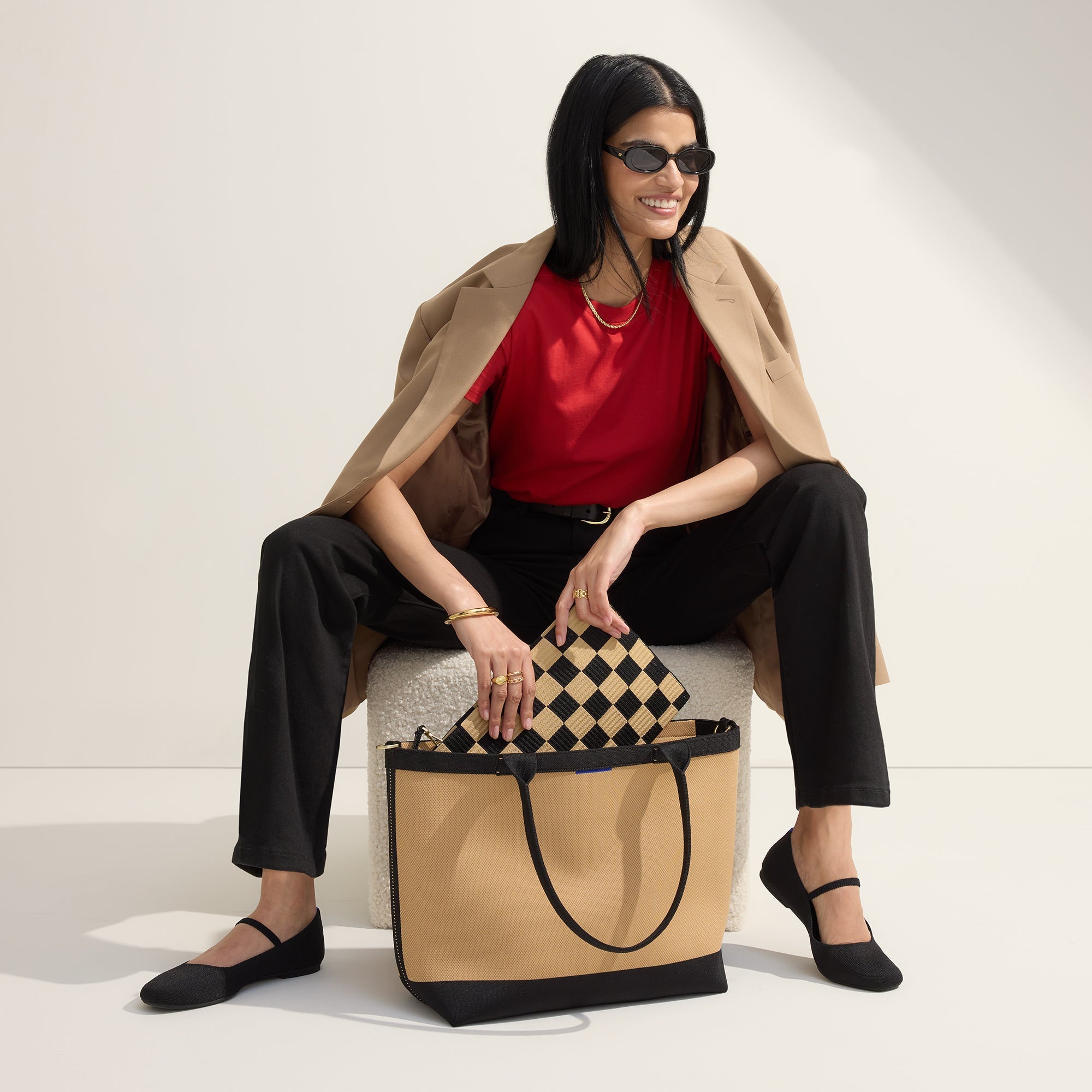 An alternate view of a model holding The Lightweight Zip Tote in Shortbread.