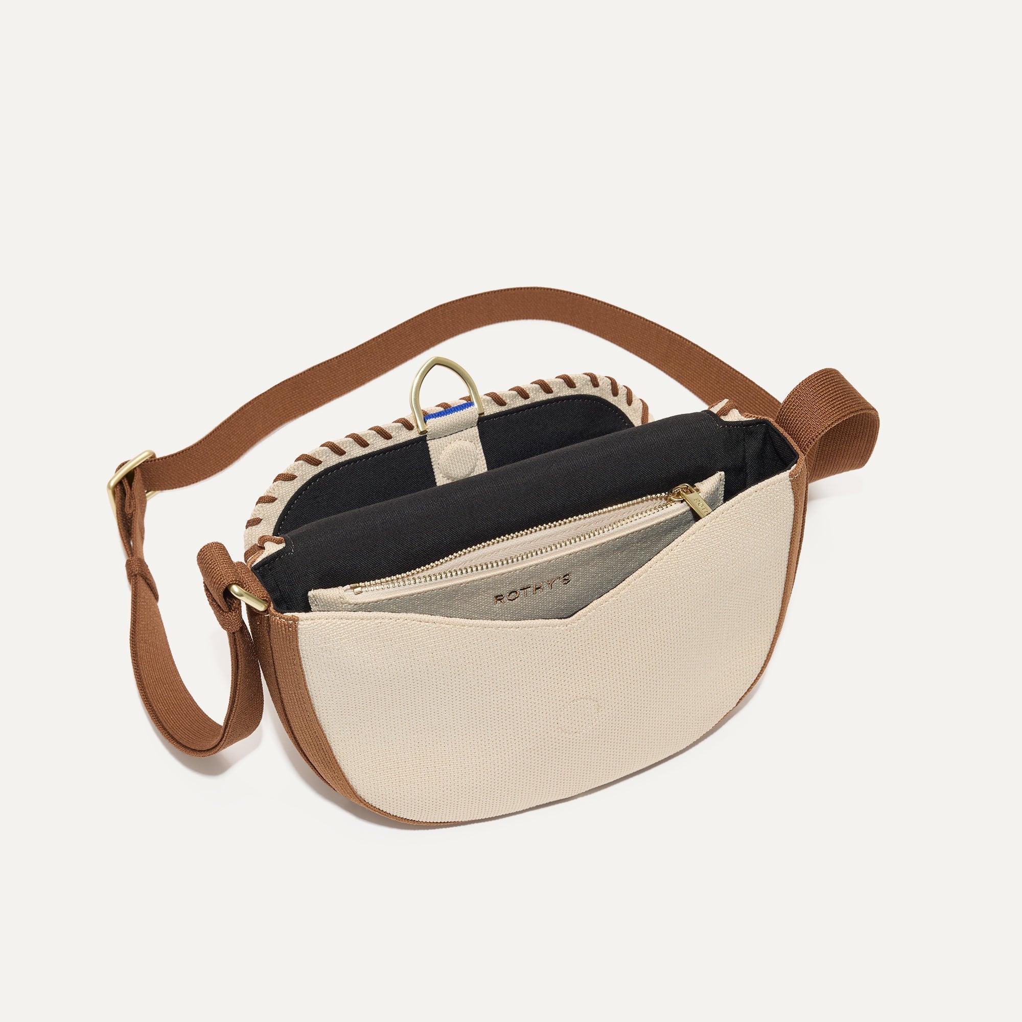 The Saddle Bag in Flat White shown open from the top showing its interior pocket.