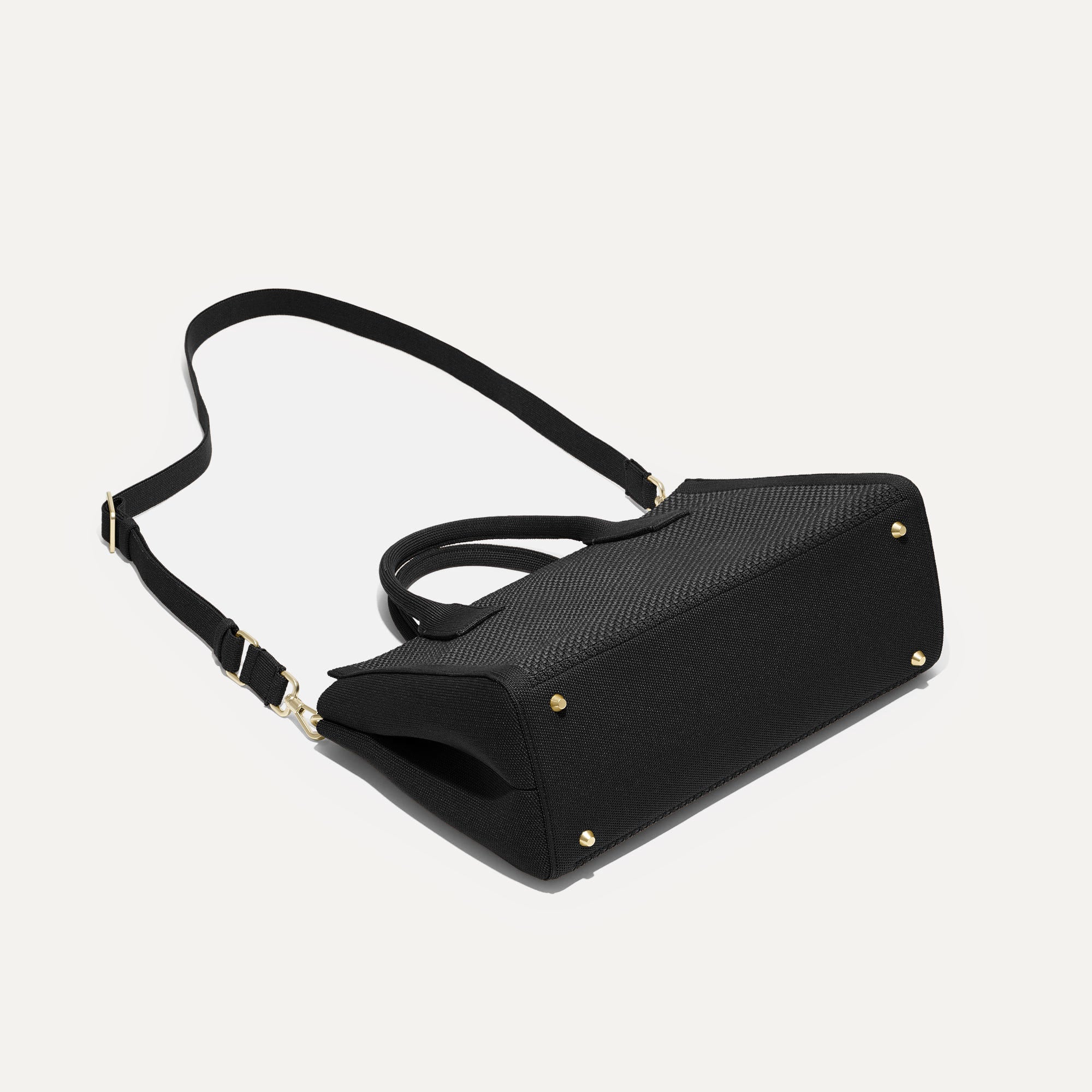 The Classic Handbag in Black shown laid down.