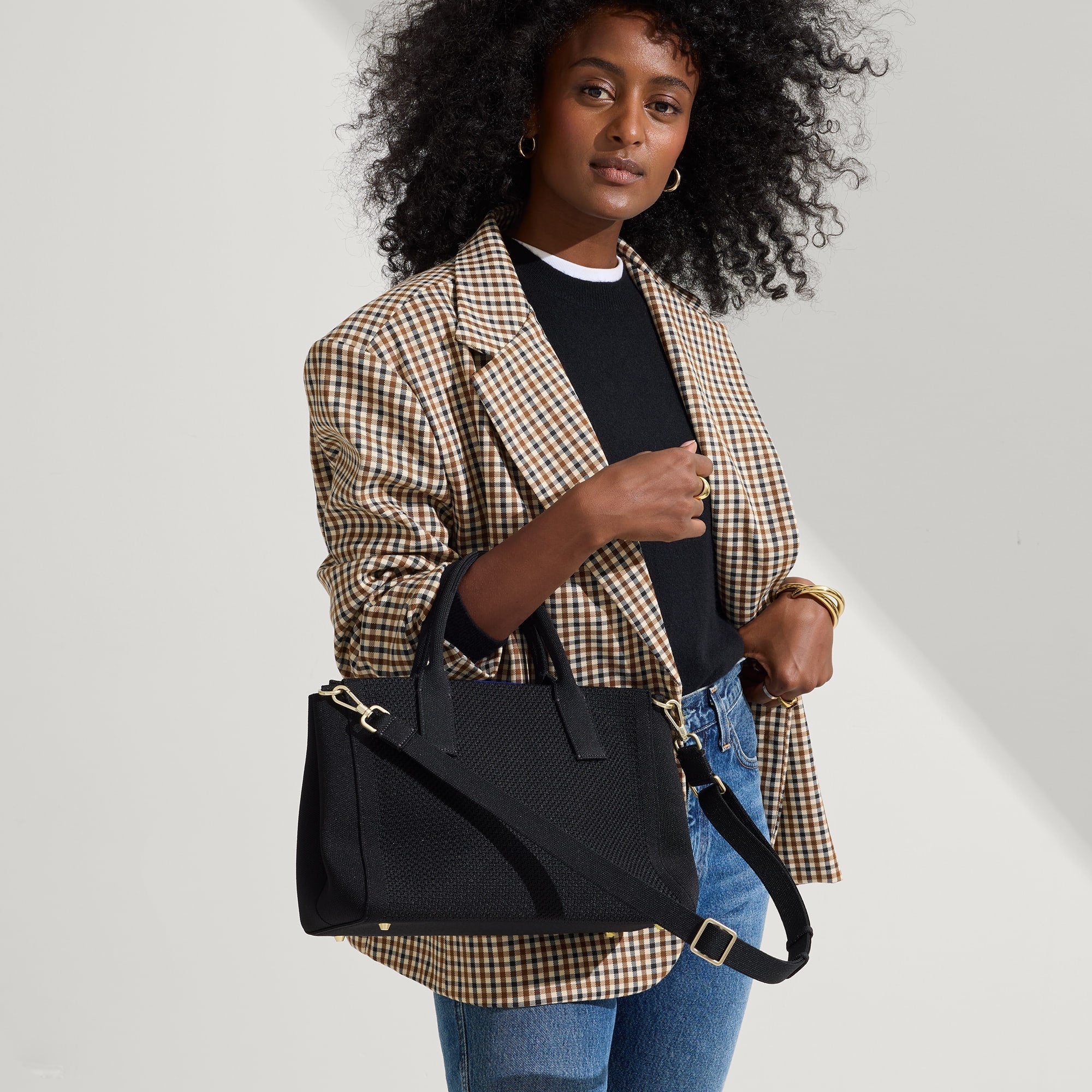 The Classic Handbag in Black being carried by a model.