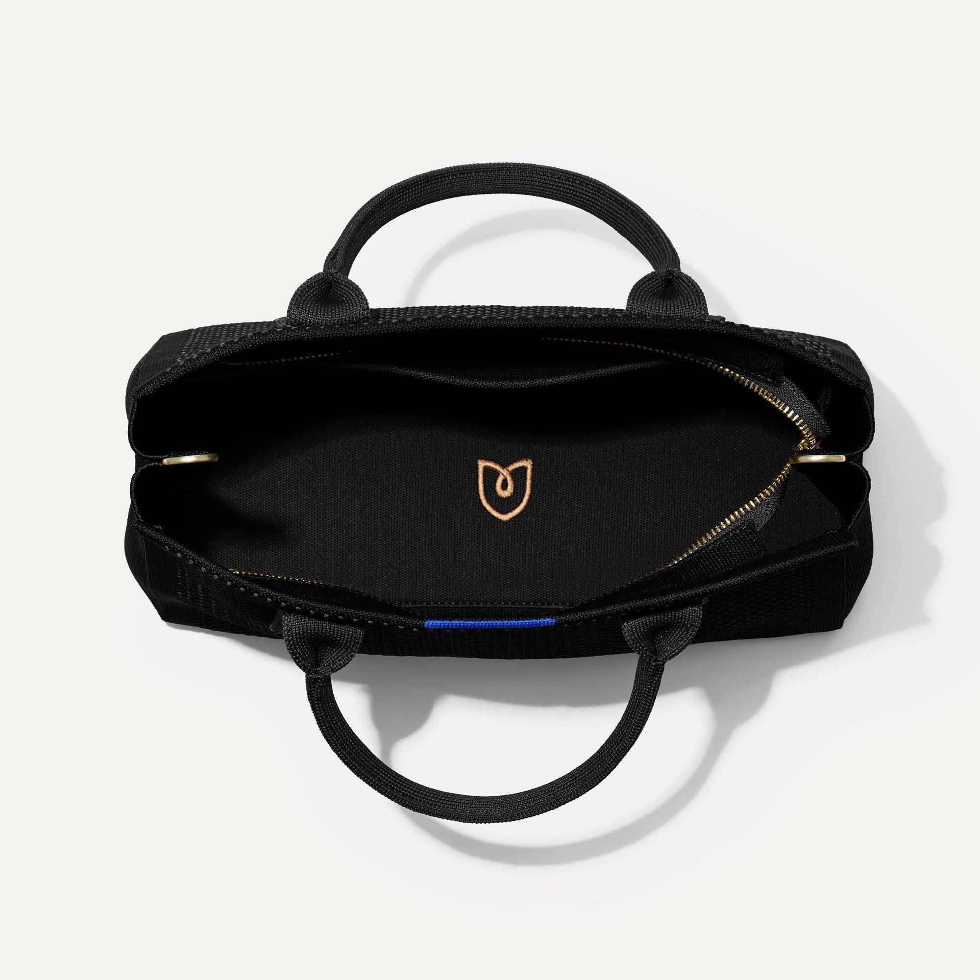 The Classic Handbag in Black shown open from the top.