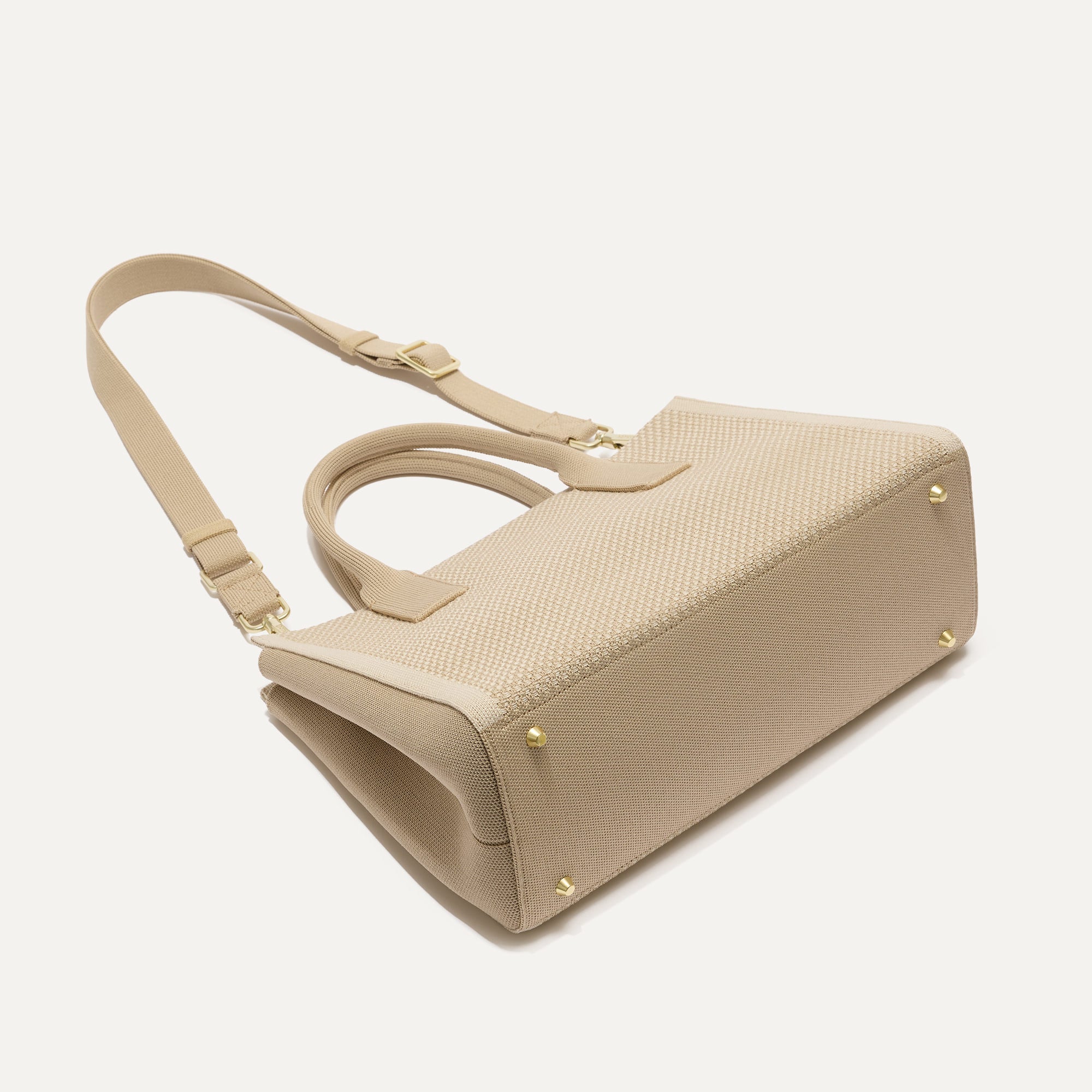 The Classic Handbag in Soft Sesame shown laid down.