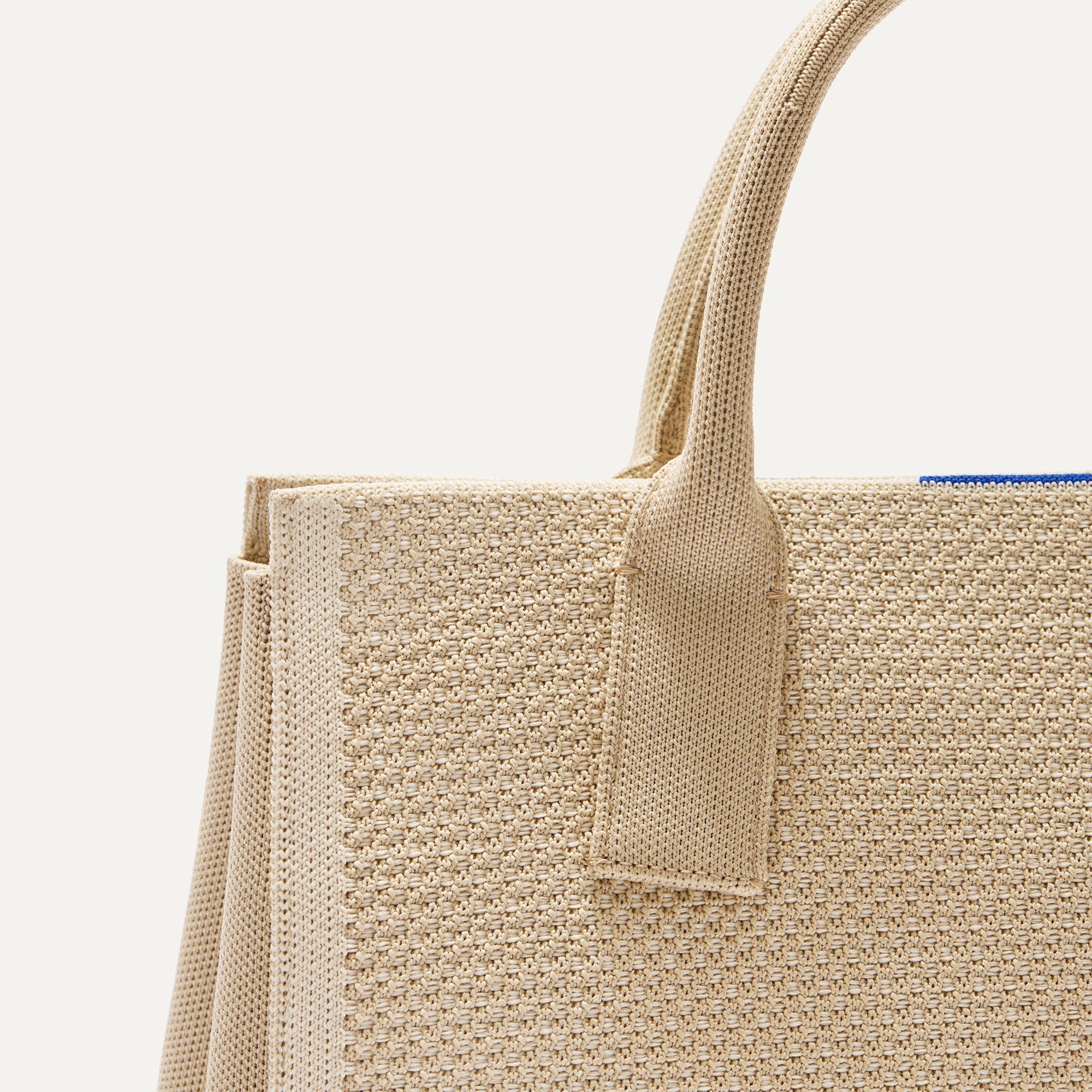 Close up look of The Classic Handbag in Soft Sesame shown laid down.