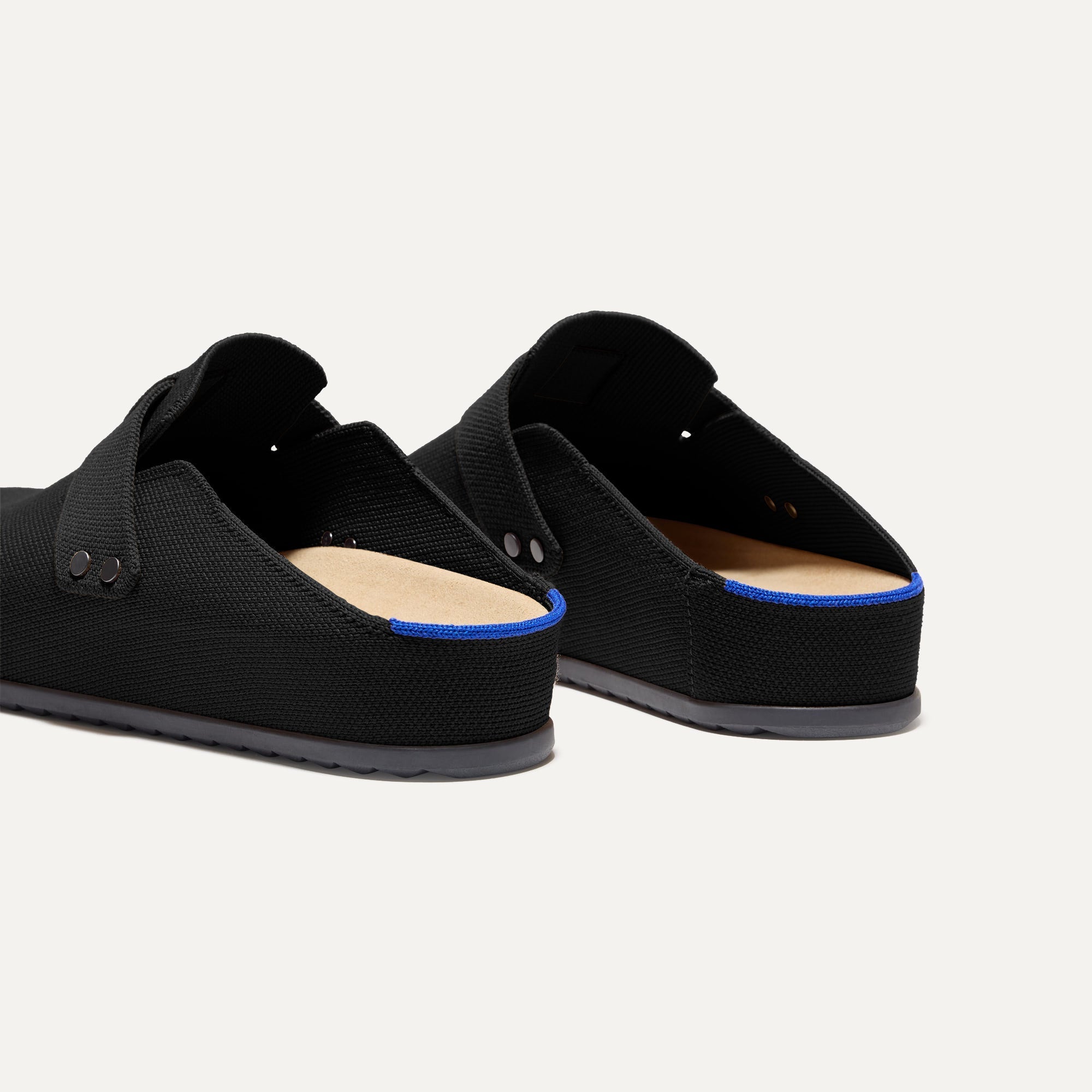 Close up of the heel of The Men's Clog in Soft Black, with Rothy's signature blue halo. 