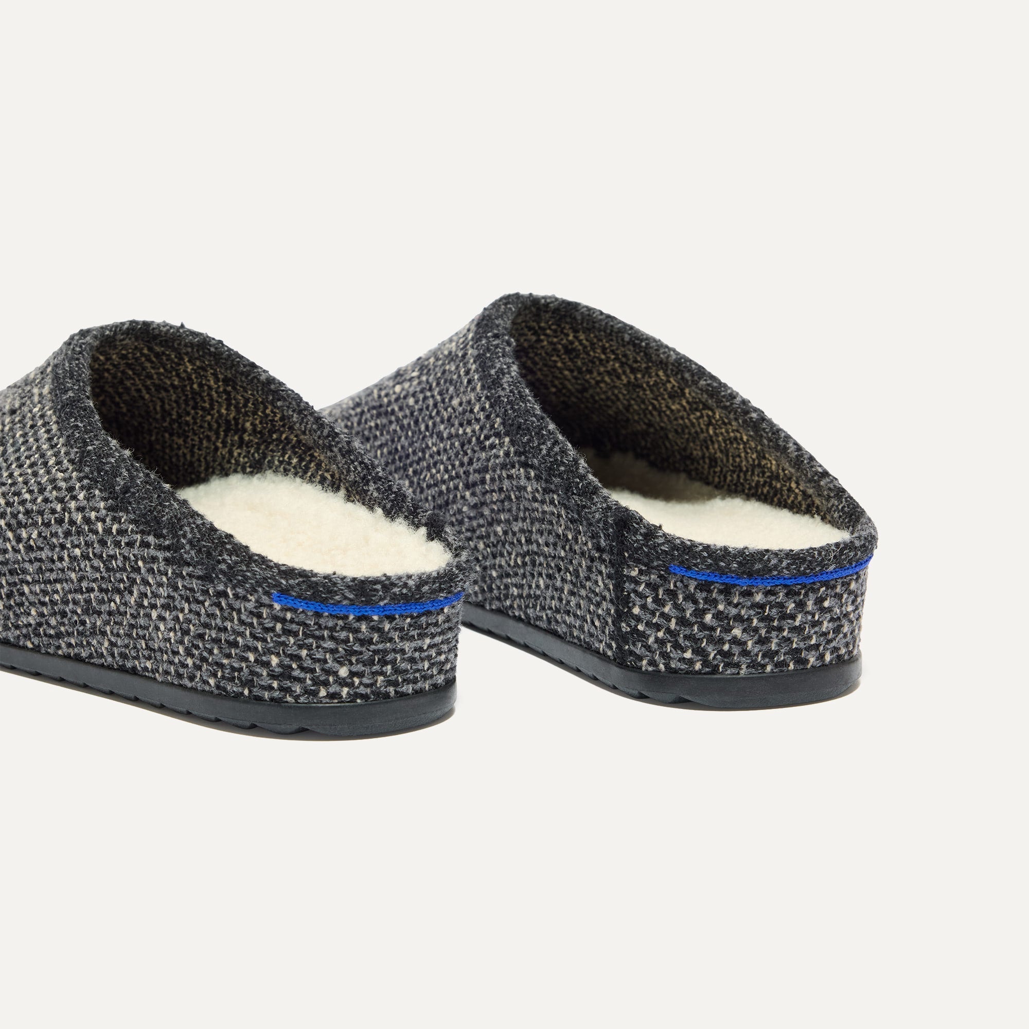 Close up of the heel of The Cozy Clog in Black Sesame Bouclé, with Rothy's signature blue halo. 