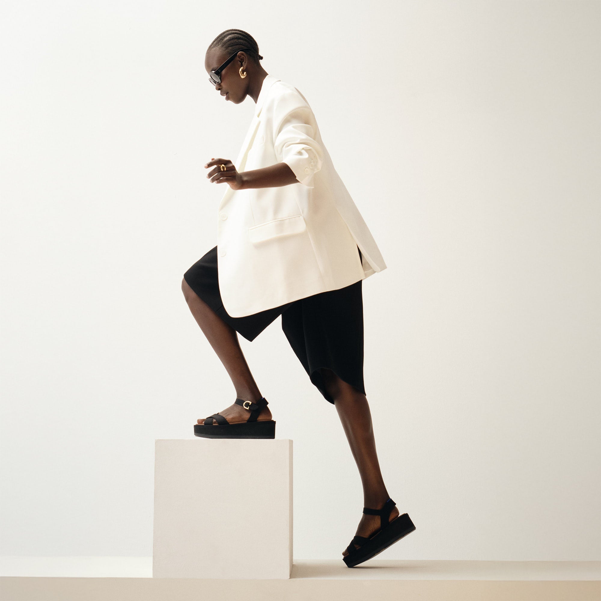 Alternate, close up view of a model wearing The Criss-Cross Lightweight Wedge Sandal in Black. 