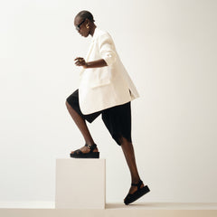 Alternate, close up view of a model wearing The Criss-Cross Lightweight Wedge Sandal in Black. 