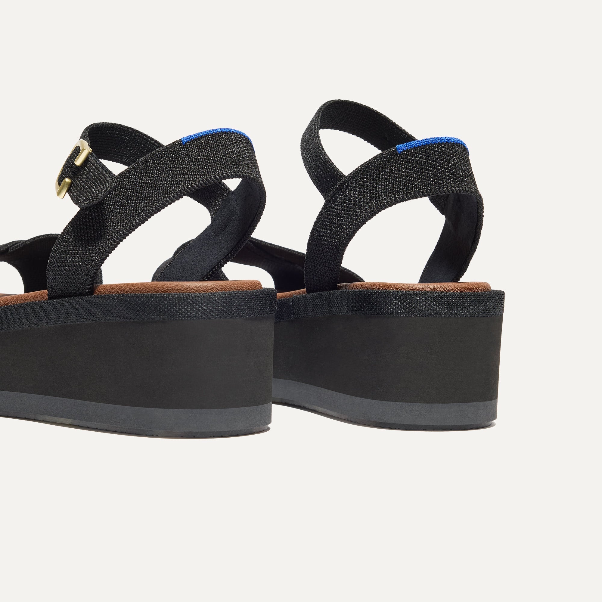 Close up of the heel of The Criss-Cross Lightweight Wedge Sandal in Black, with Rothy's signature blue halo.