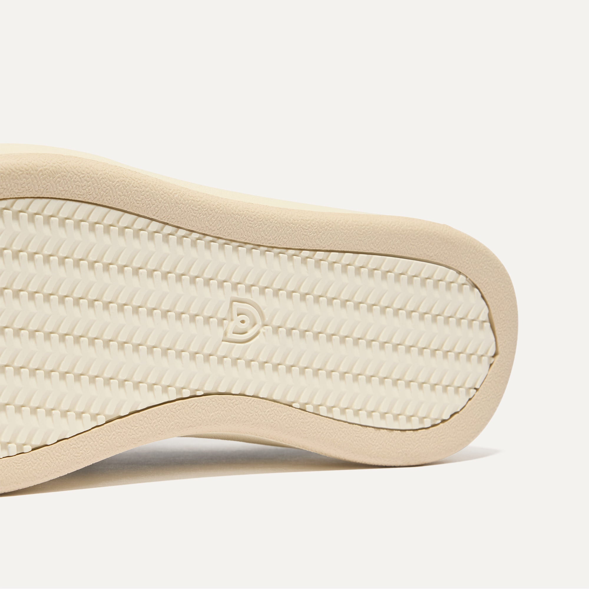 Close up of the outsoles of The Court Sneaker in Black, with raised grooves for added traction. 
