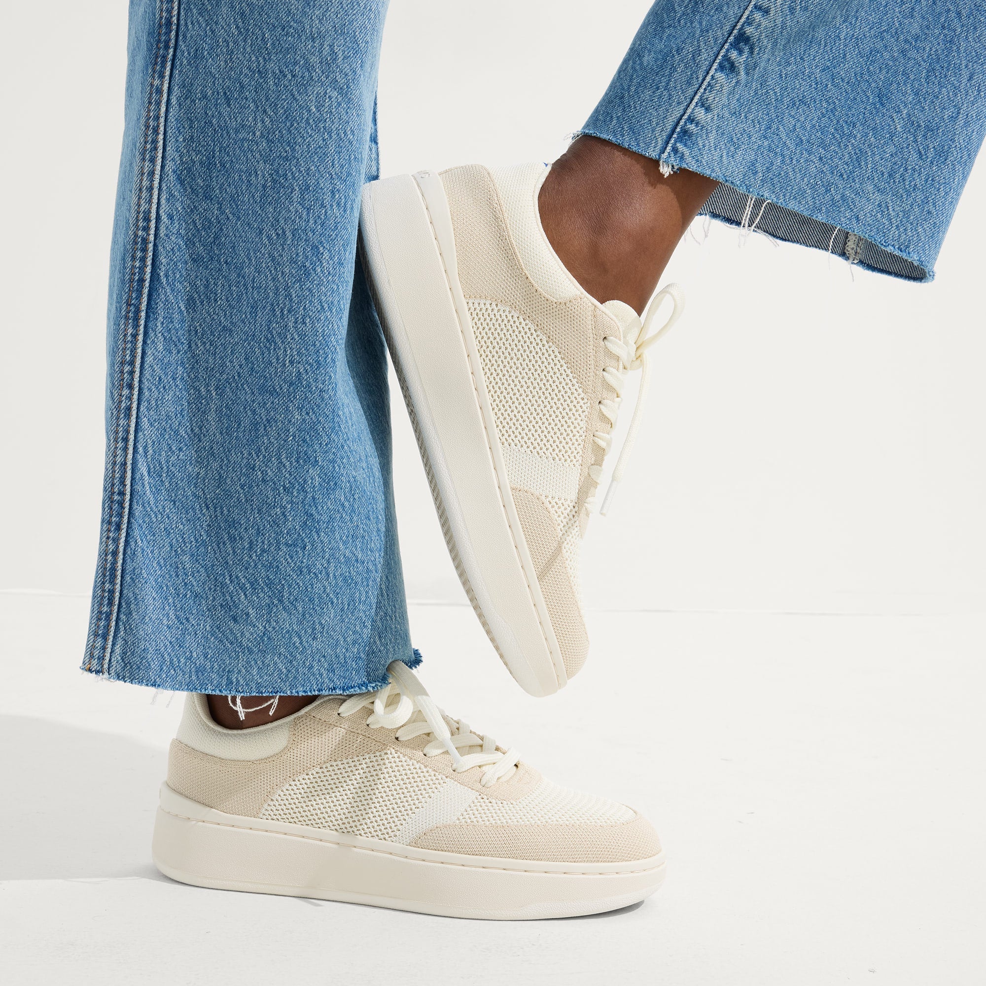 hover | Model wearing The Court Sneaker in Sand Dune.