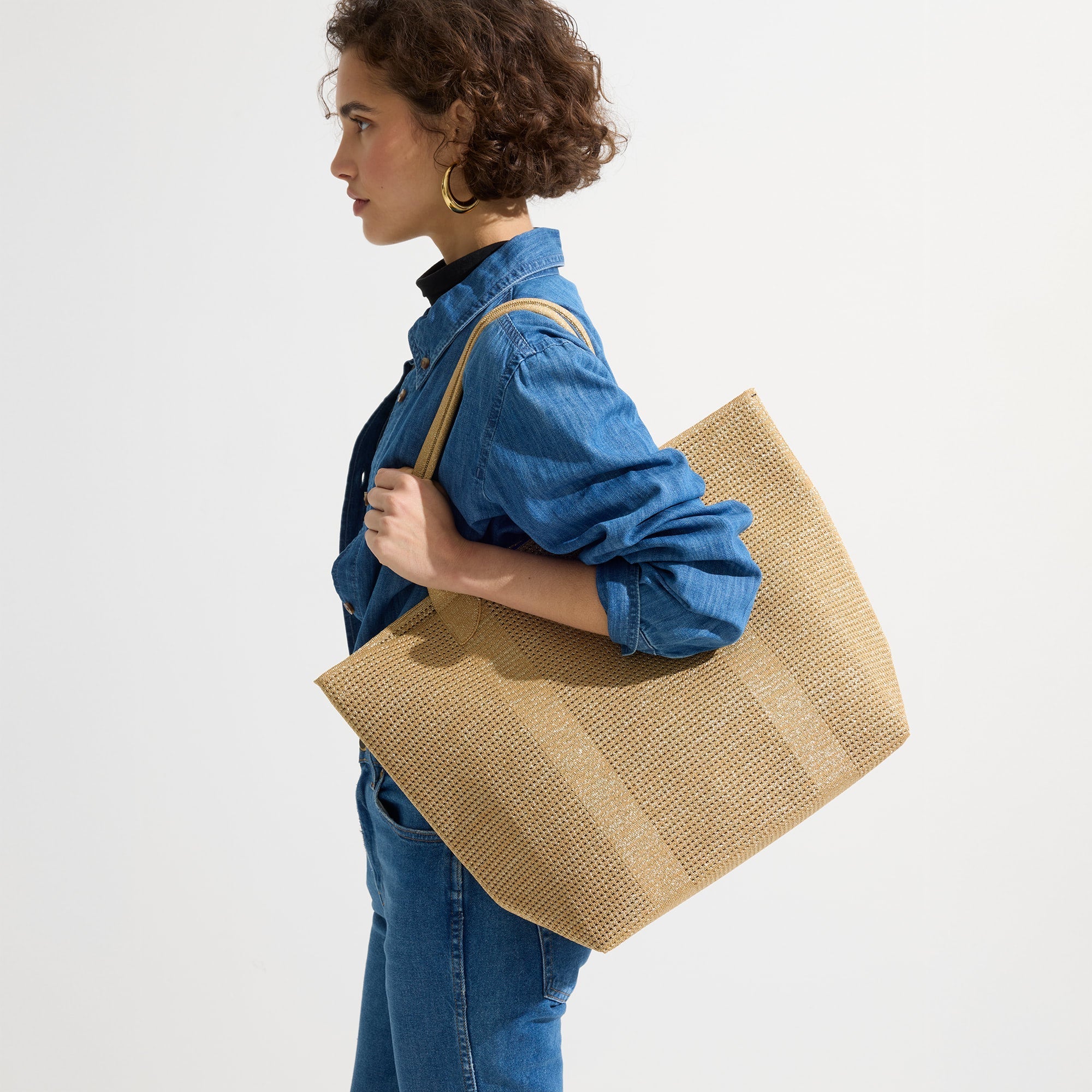 hover | Model holding The Lightweight Tote in Golden Perf.