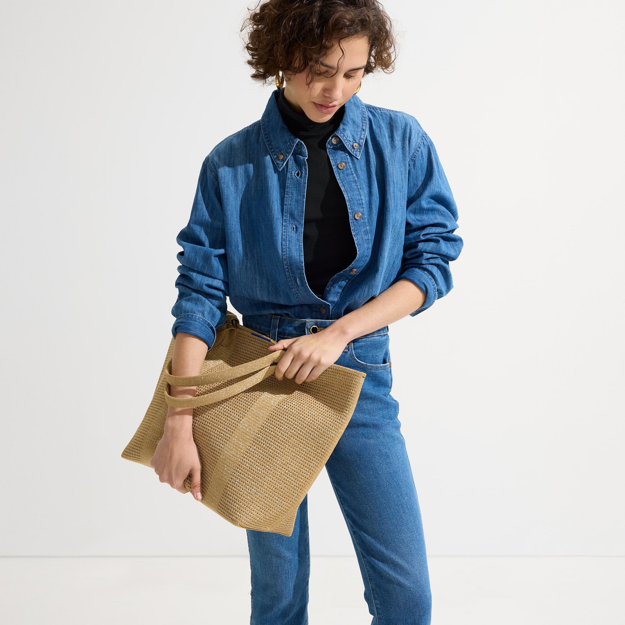 An alternate view of model holding The Lightweight Tote in Golden Perf.