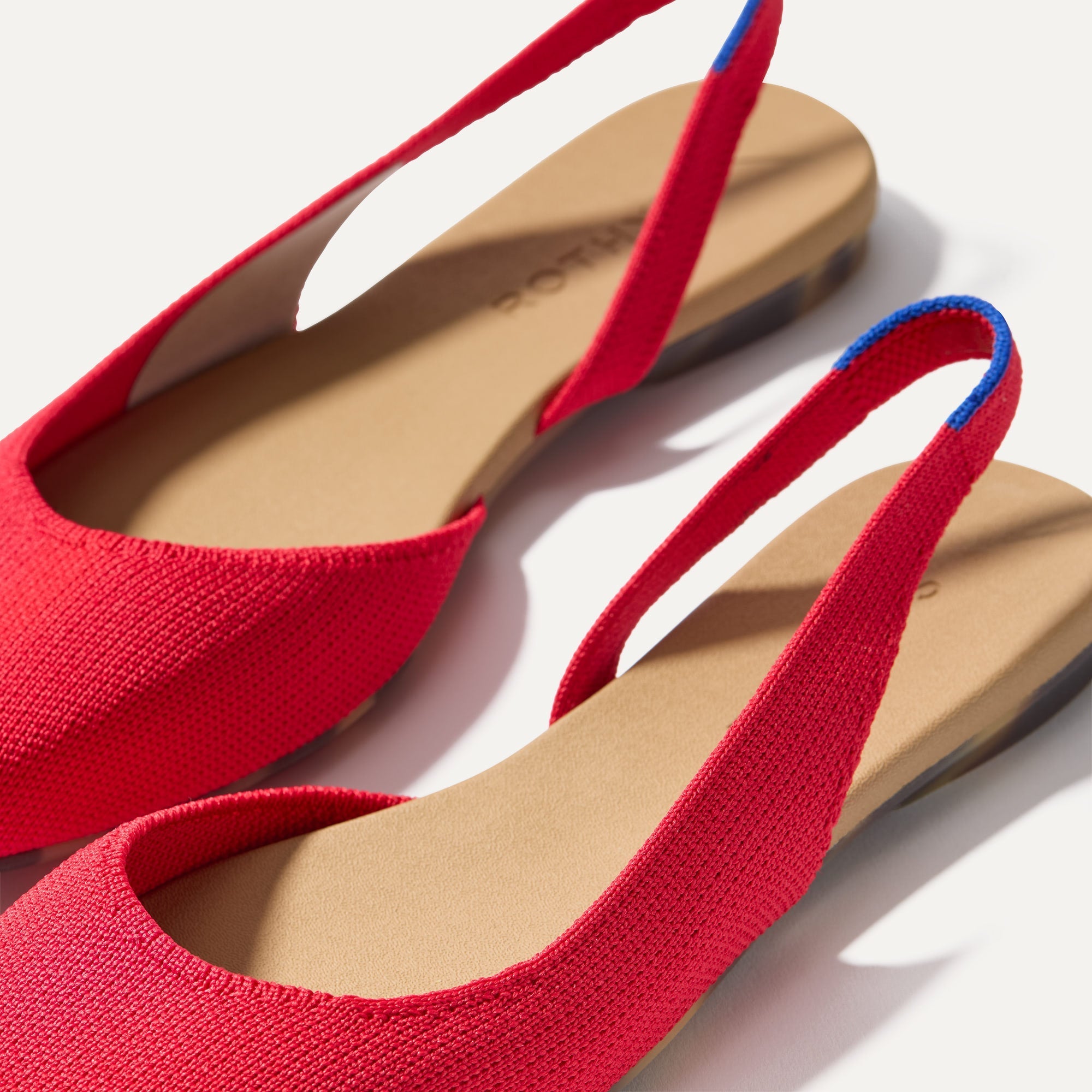 Close up of the strap on The Almond Slingback in Lollipop Red, with Rothy's signature blue halo.