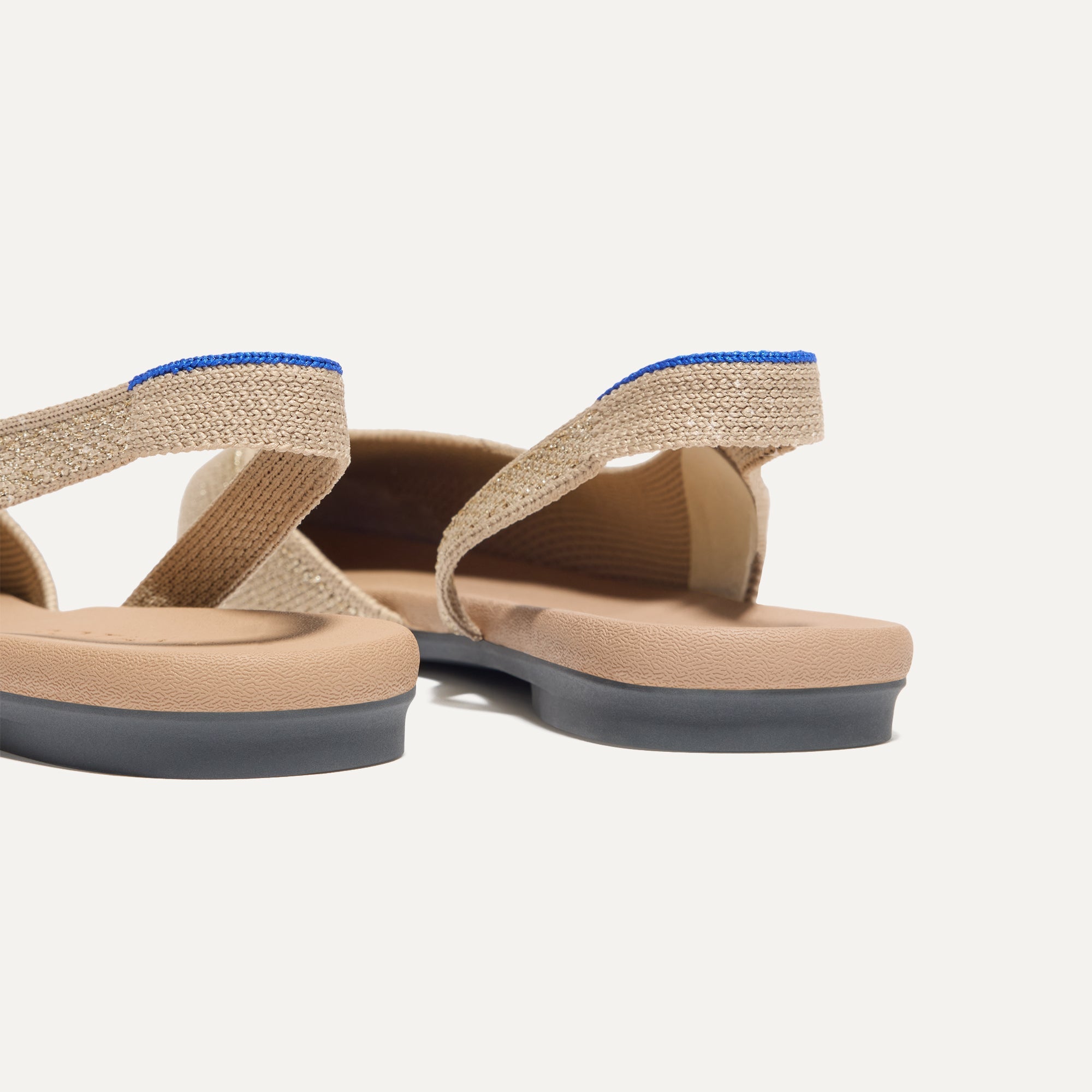 Close up of the heel The Almond Slingback in Metallic Prosecco, with Rothy's signature blue halo.