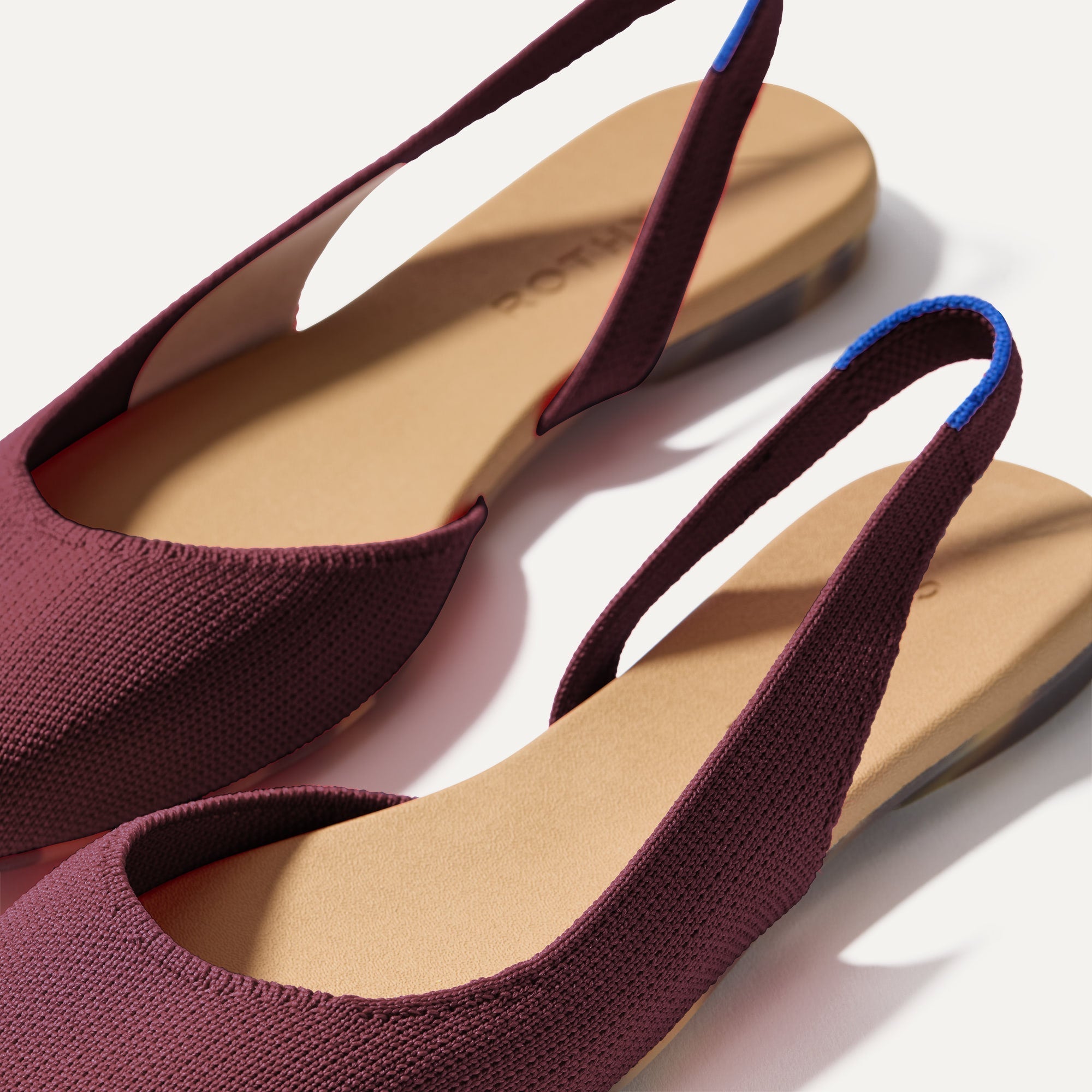 Close up of the strap on The Almond Slingback in Syrah, with Rothy's signature blue halo.
