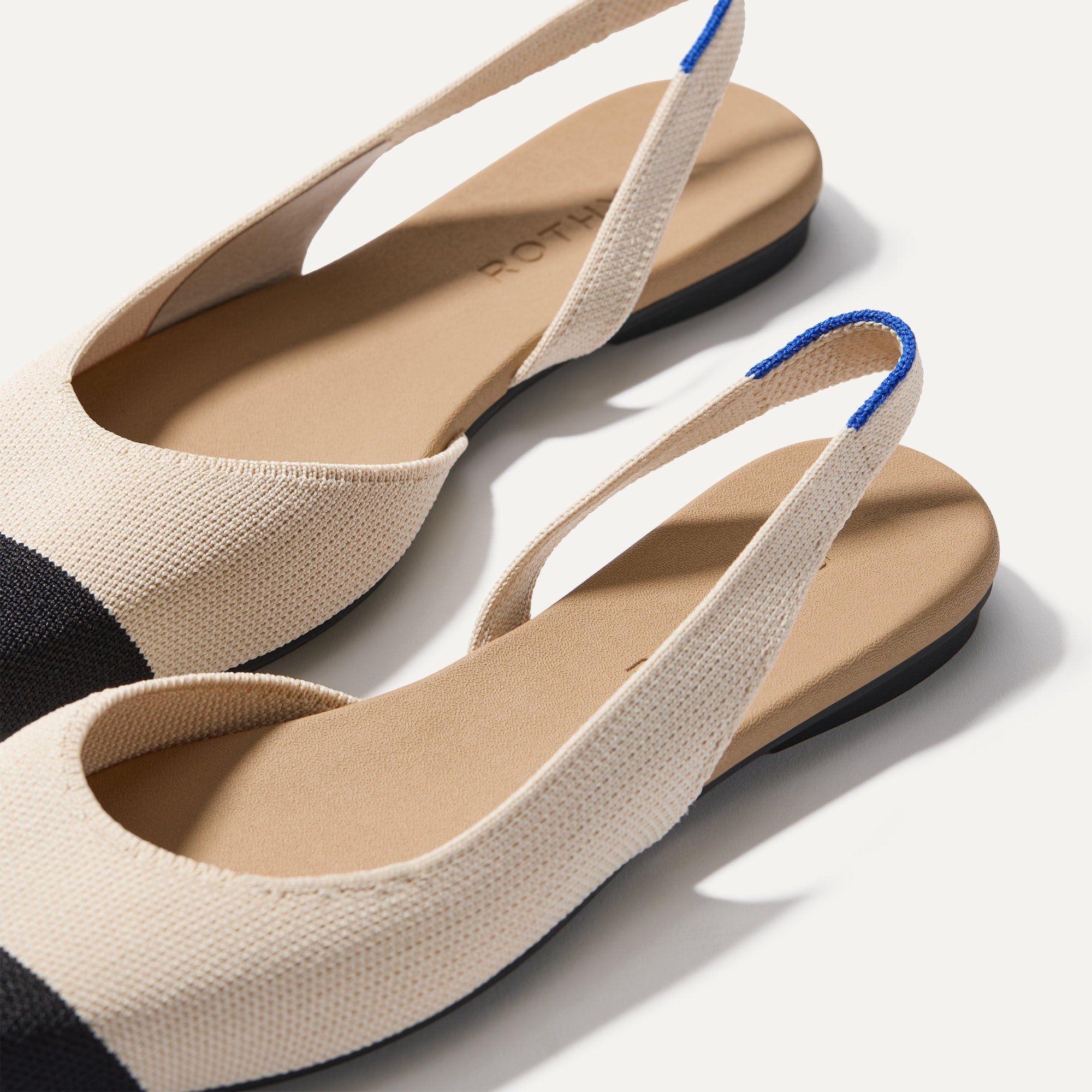 Close up of the strap on The Almond Slingback in Conch Captoe, with Rothy's signature blue halo.