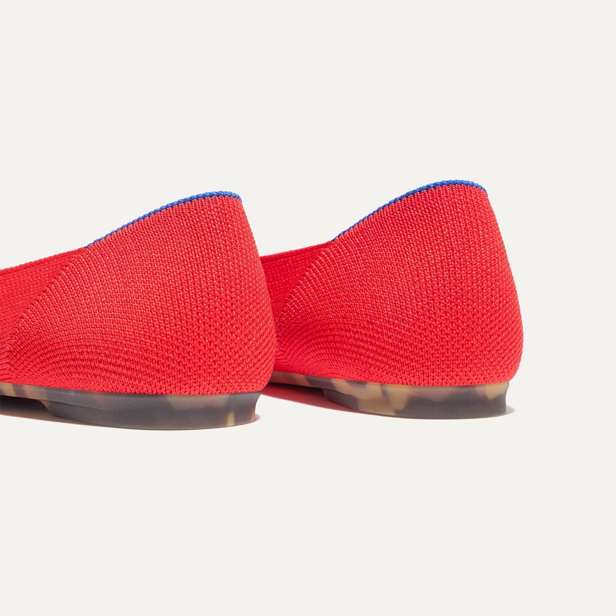 Close up of the heel of The Emblem Ballet Flat in Cardinal, with Rothy's signature blue halo. 