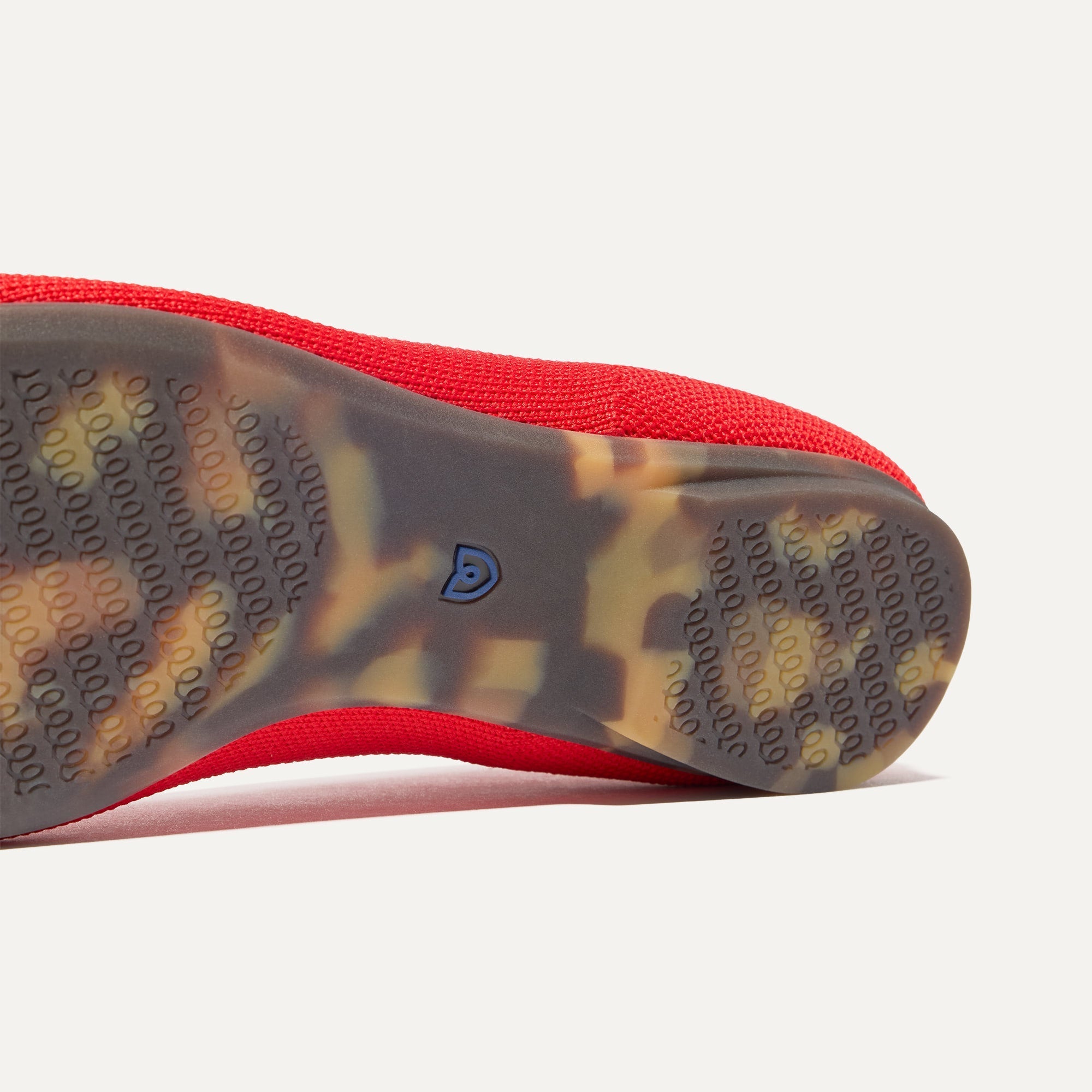 The sole of The Emblem Ballet Flat in Cardinal shown in diagonal view.