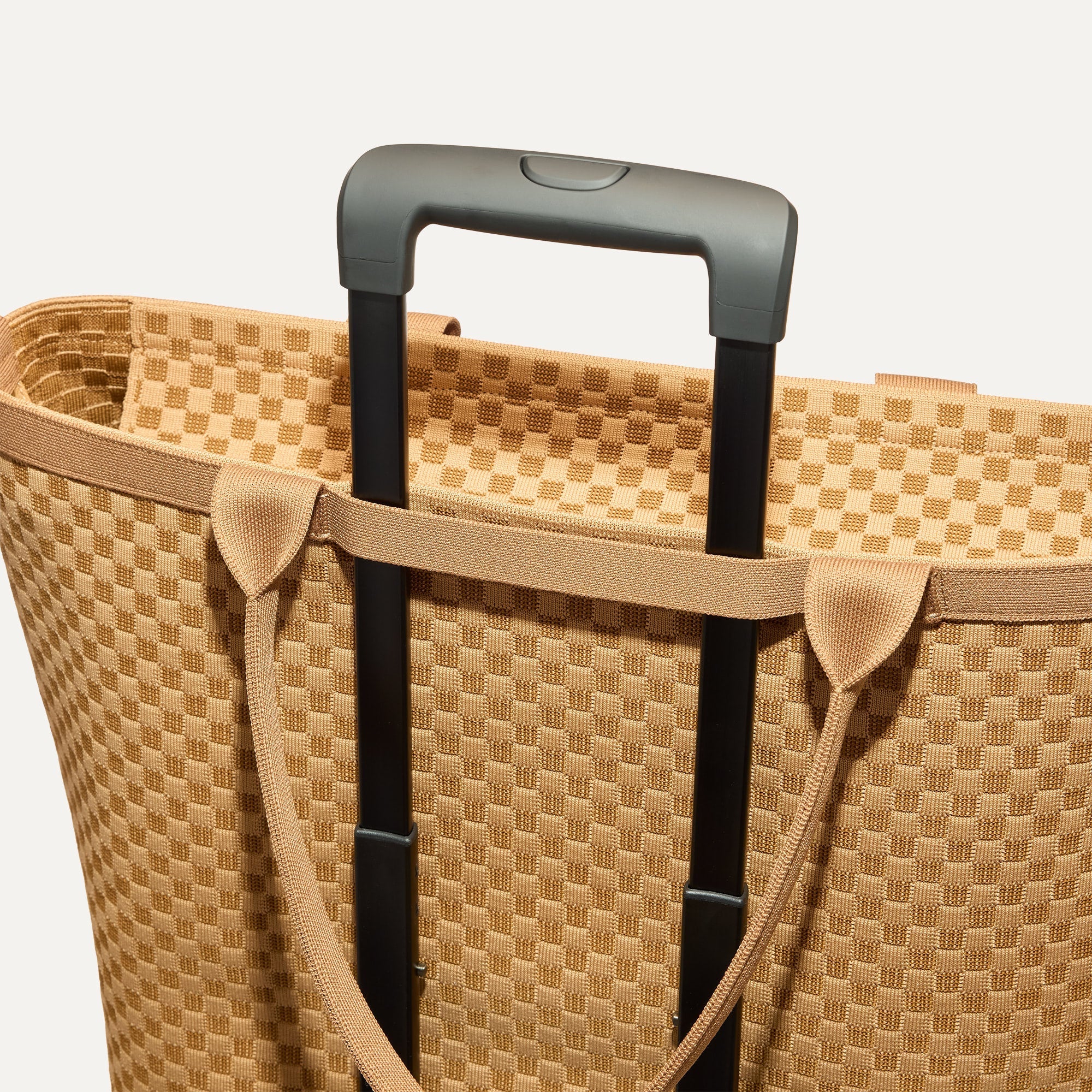 The Zip Travel Tote shown attached to a rolling suitcase using the wrap-around band.