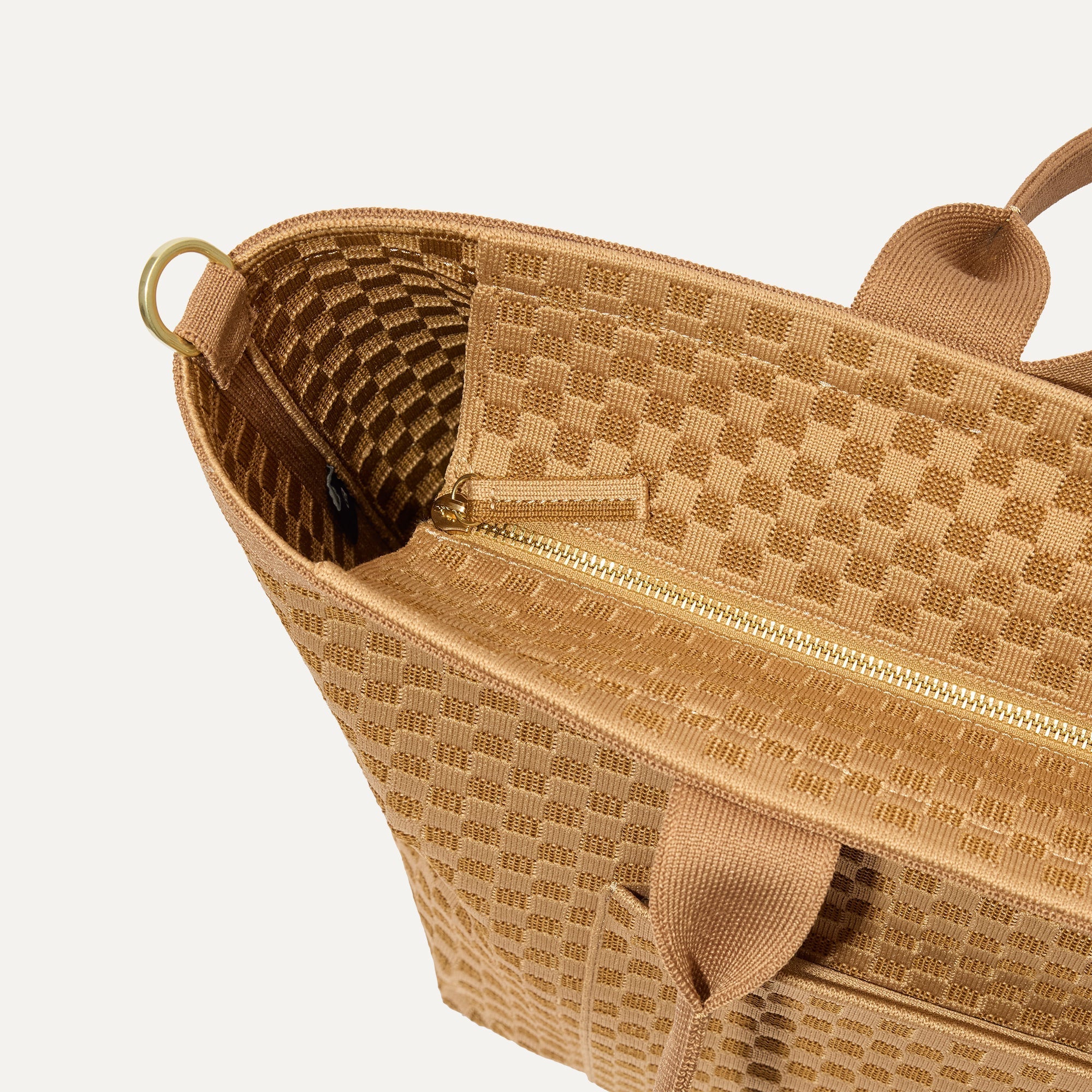 A close up of The Zip Travel Tote in Hazelnut focusing on the zip closure and handles.