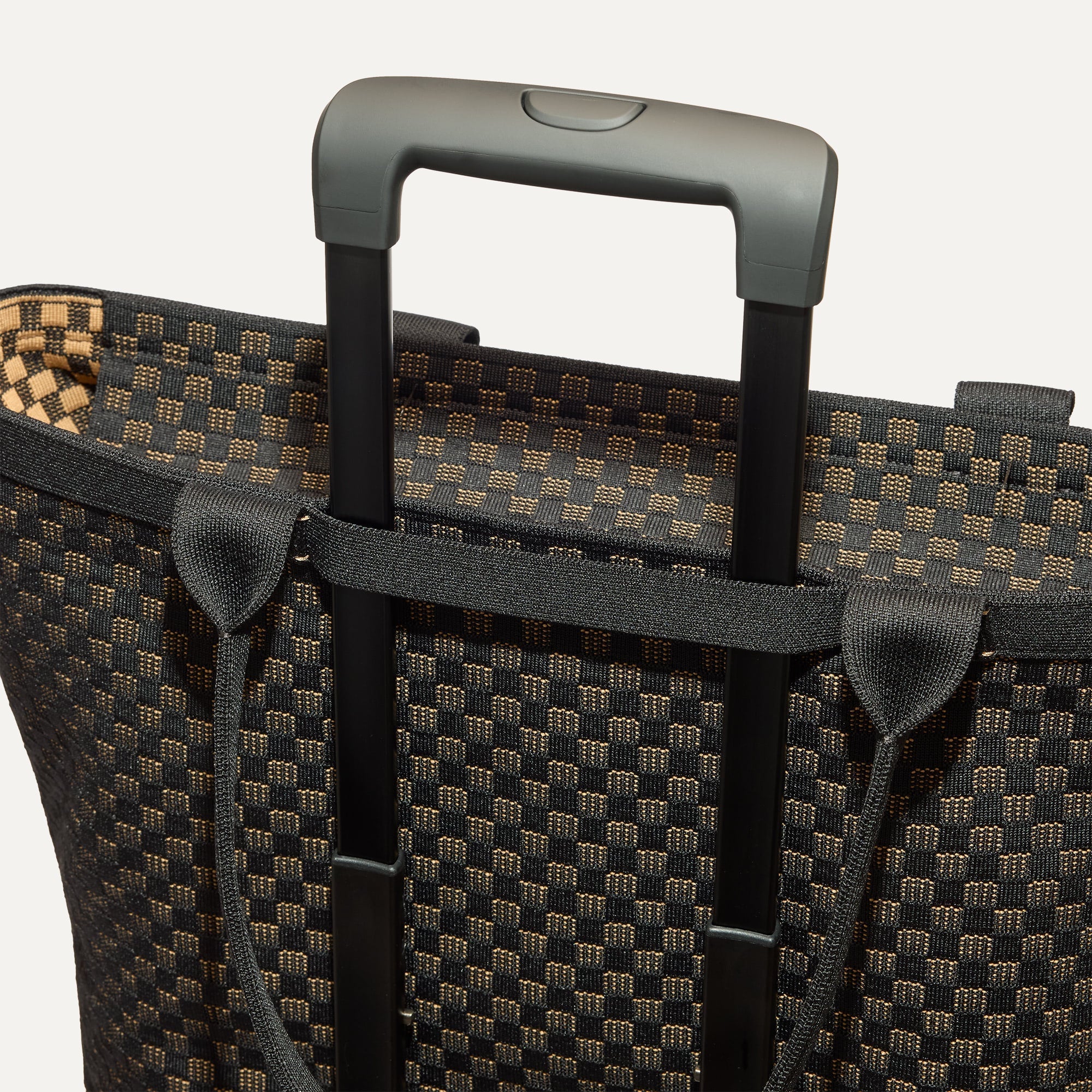 The Zip Travel Tote shown attached to a rolling suitcase using the wrap-around band.