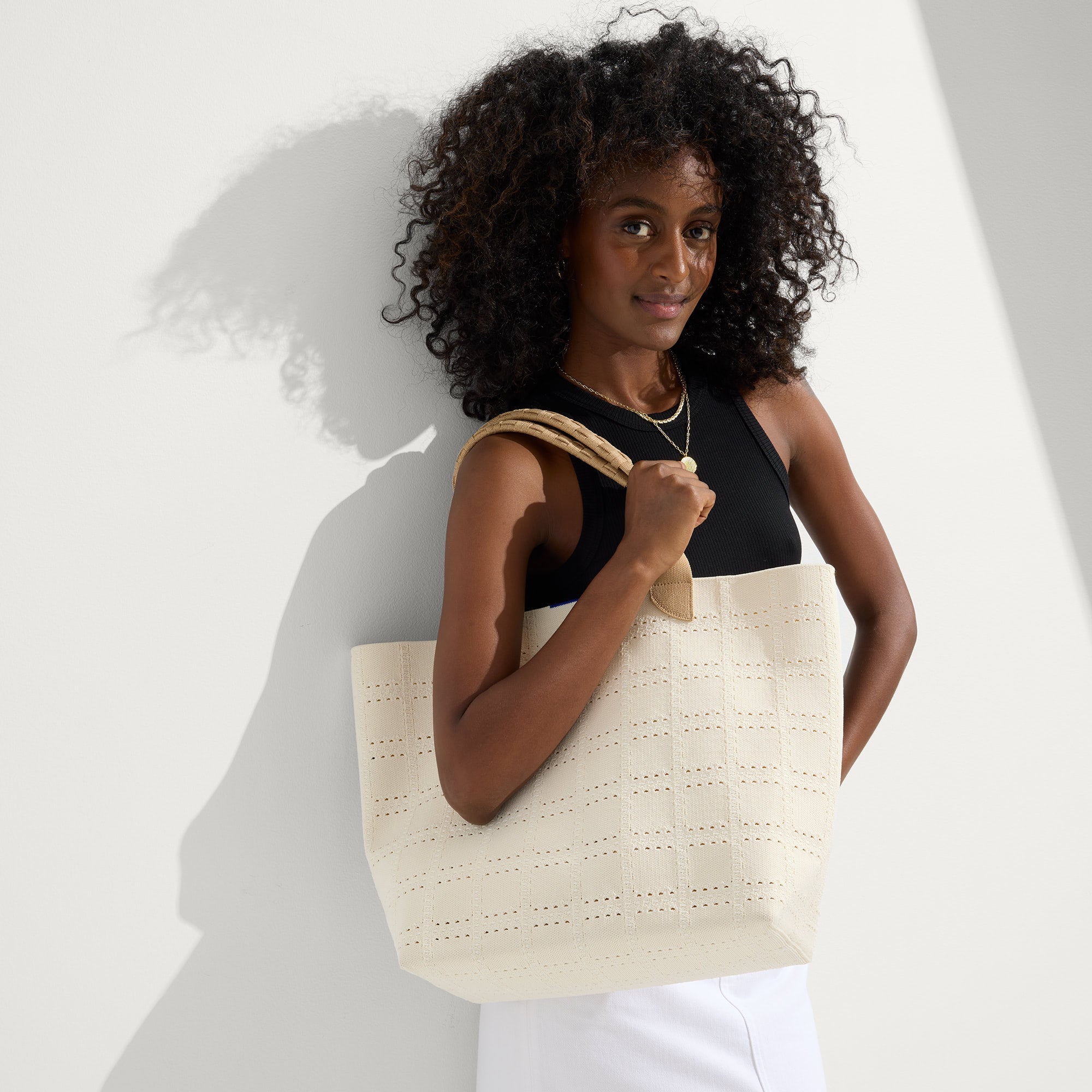 Alternate view of a model holding The Lightweight Tote in Ivory Perf.