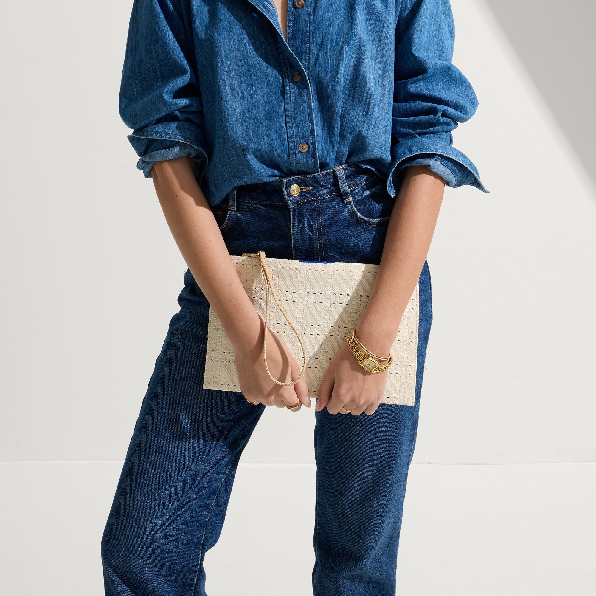 hover | Model shown holding The Wristlet in Ivory Perf.