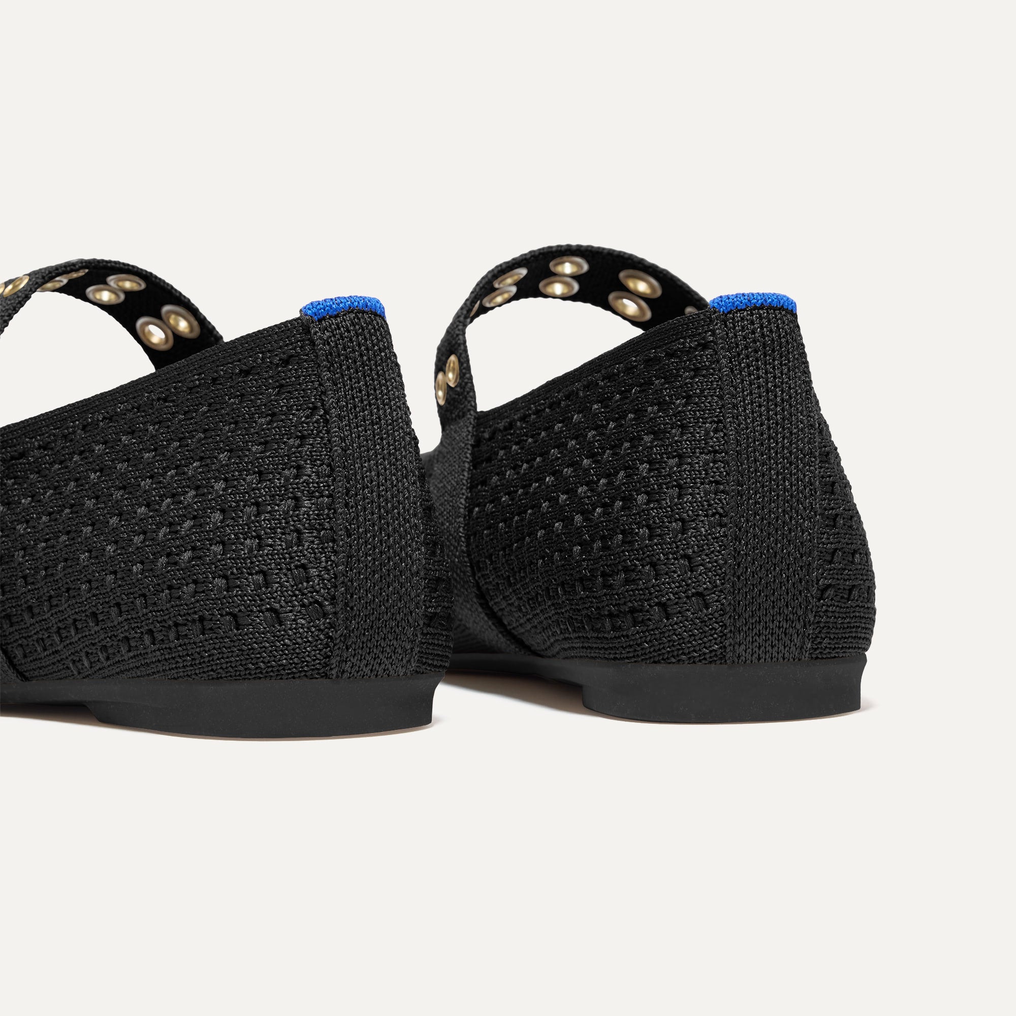 Close up of the heel of The Max Buckle Mary Jane in Black Mesh, with Rothy's signature blue halo.