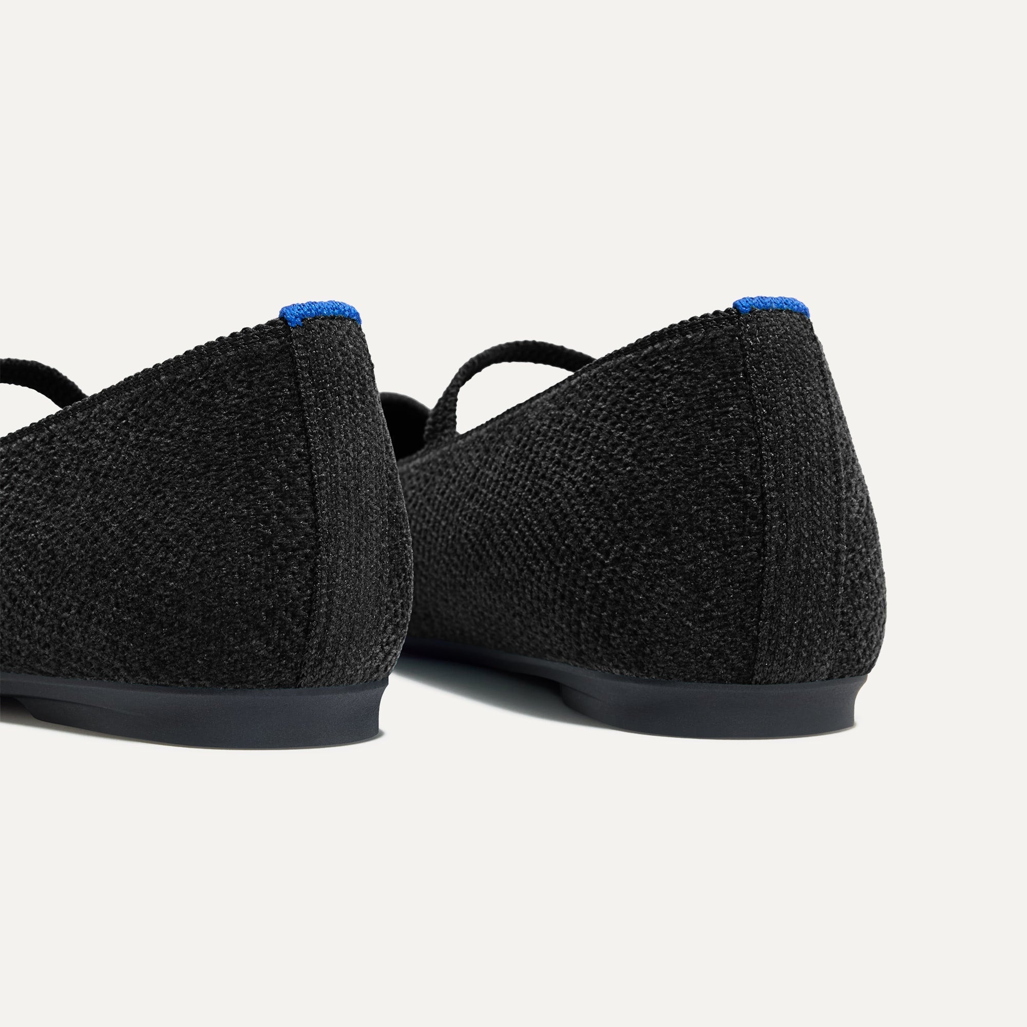 Close up of the heel of The Max Square Mary Jane in ReVelvet™ Black, with Rothy's signature blue halo.