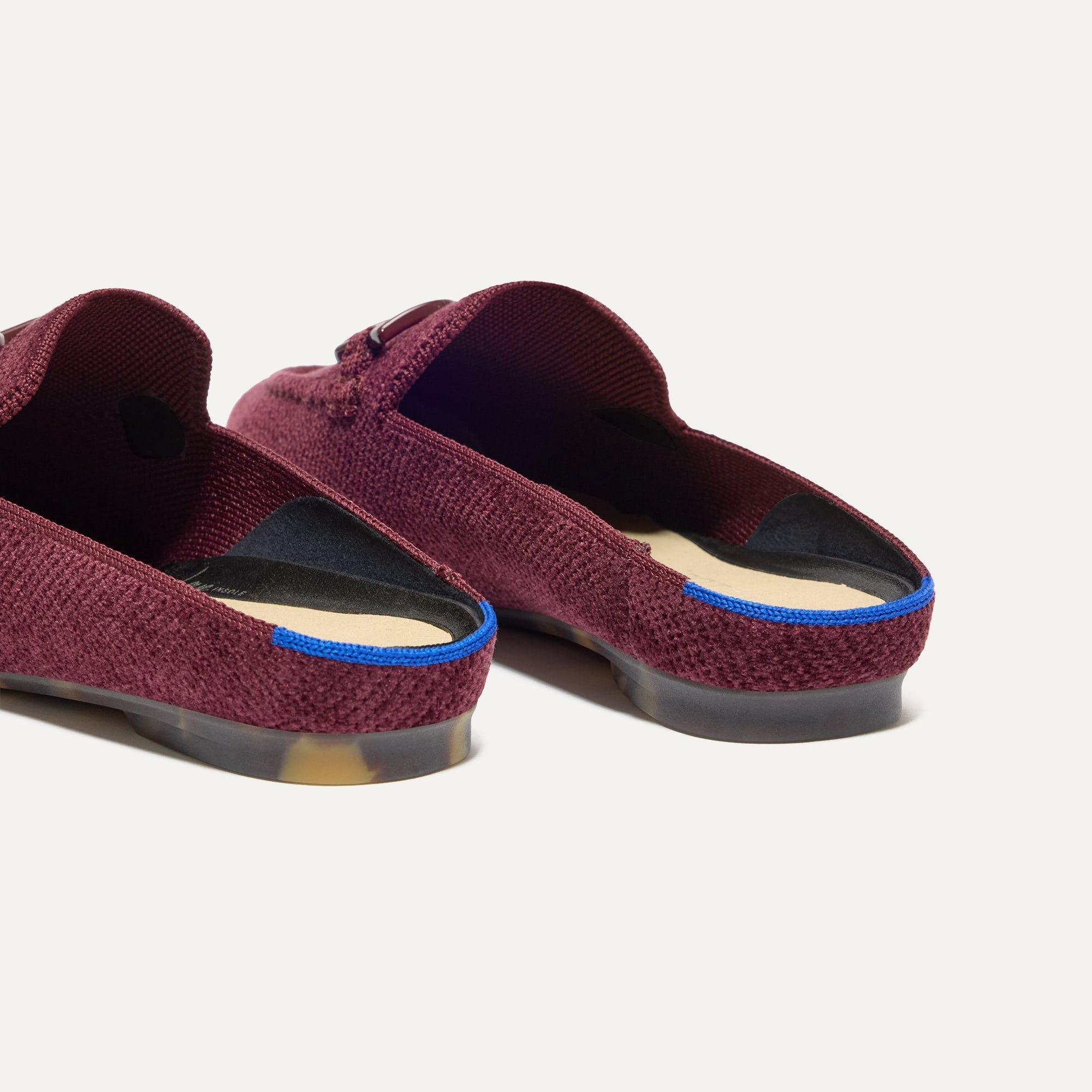 Close up of the heel of The Double Bit Loafer Mule in ReVelvet™ Syrah, with Rothy's signature blue halo. 